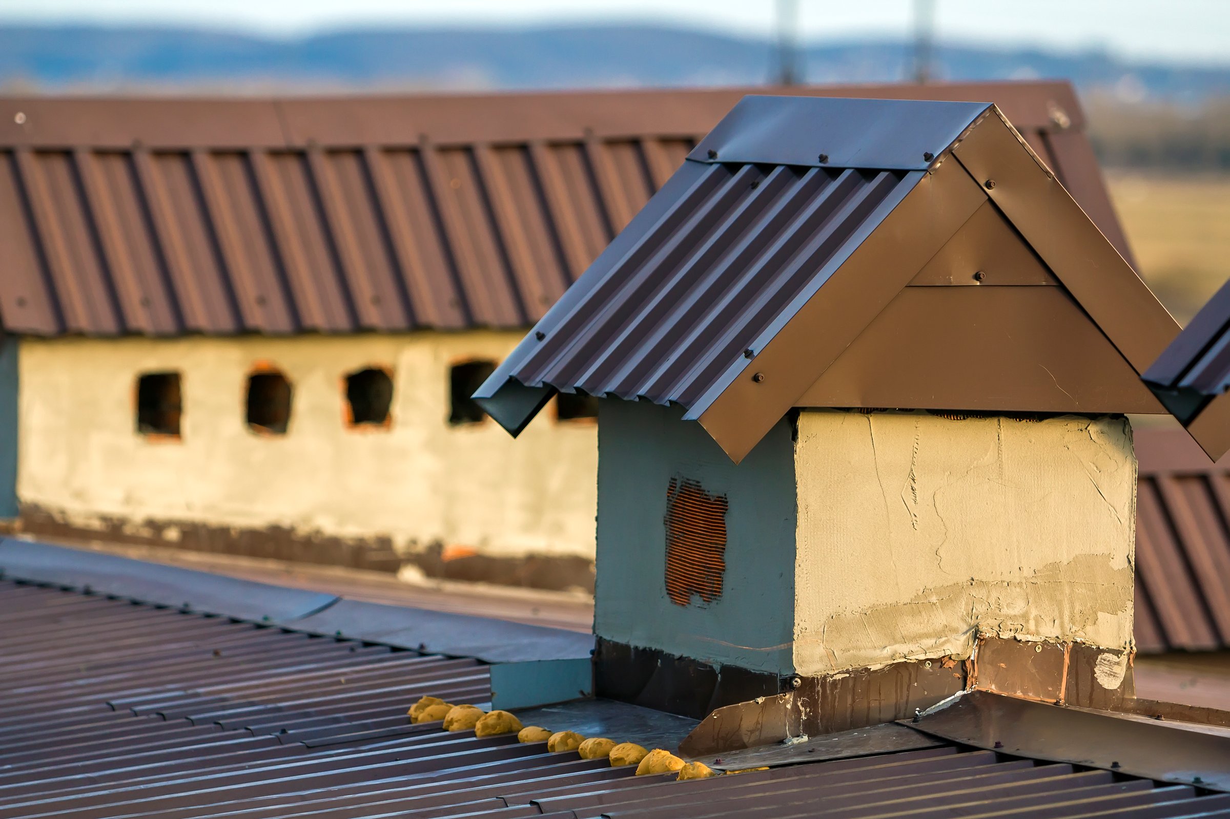 Close-up of a new built chimney on a house roof under construction. Unfinished building, repair and renovation work.