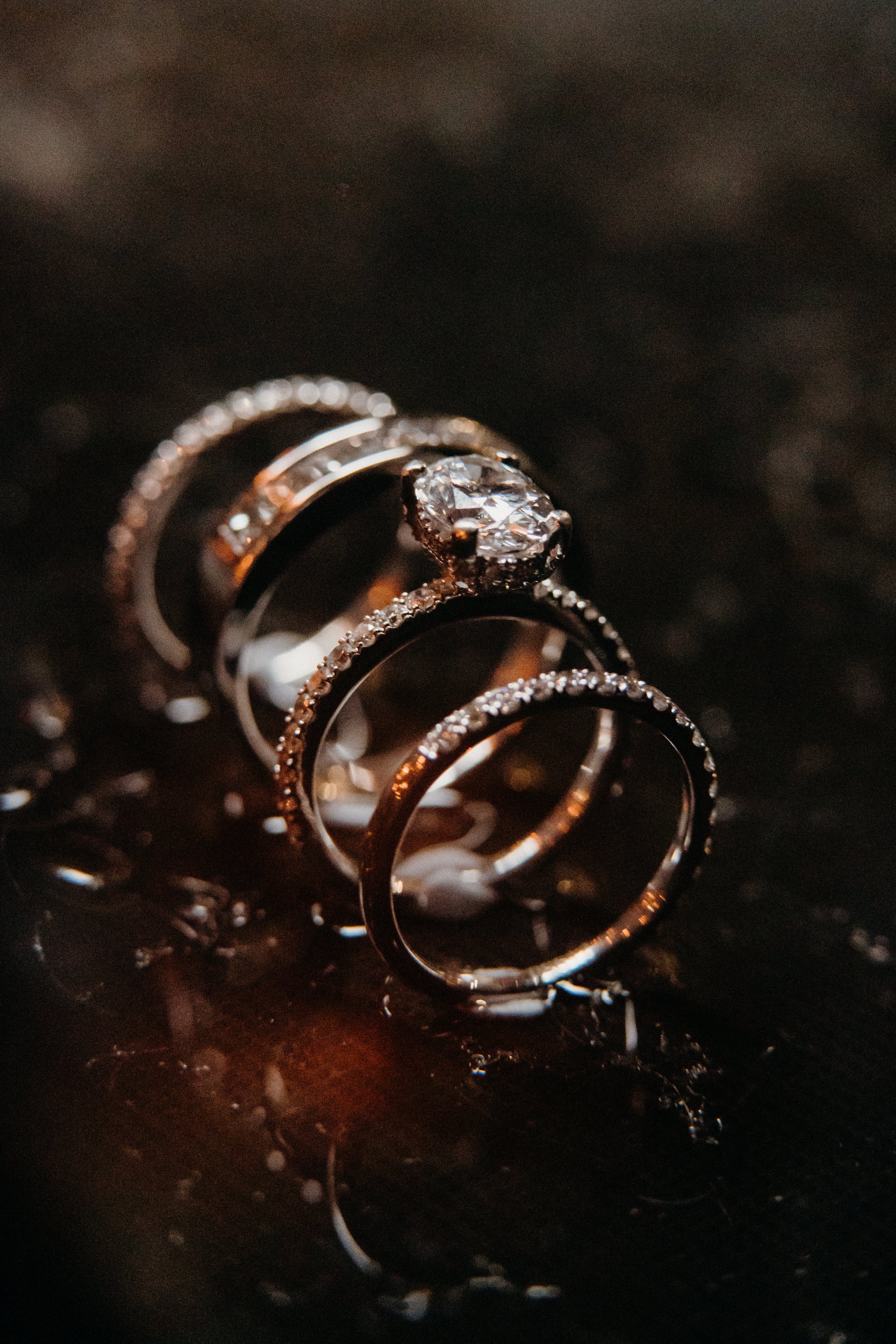 Close-up of two gold wedding bands on dark marble background