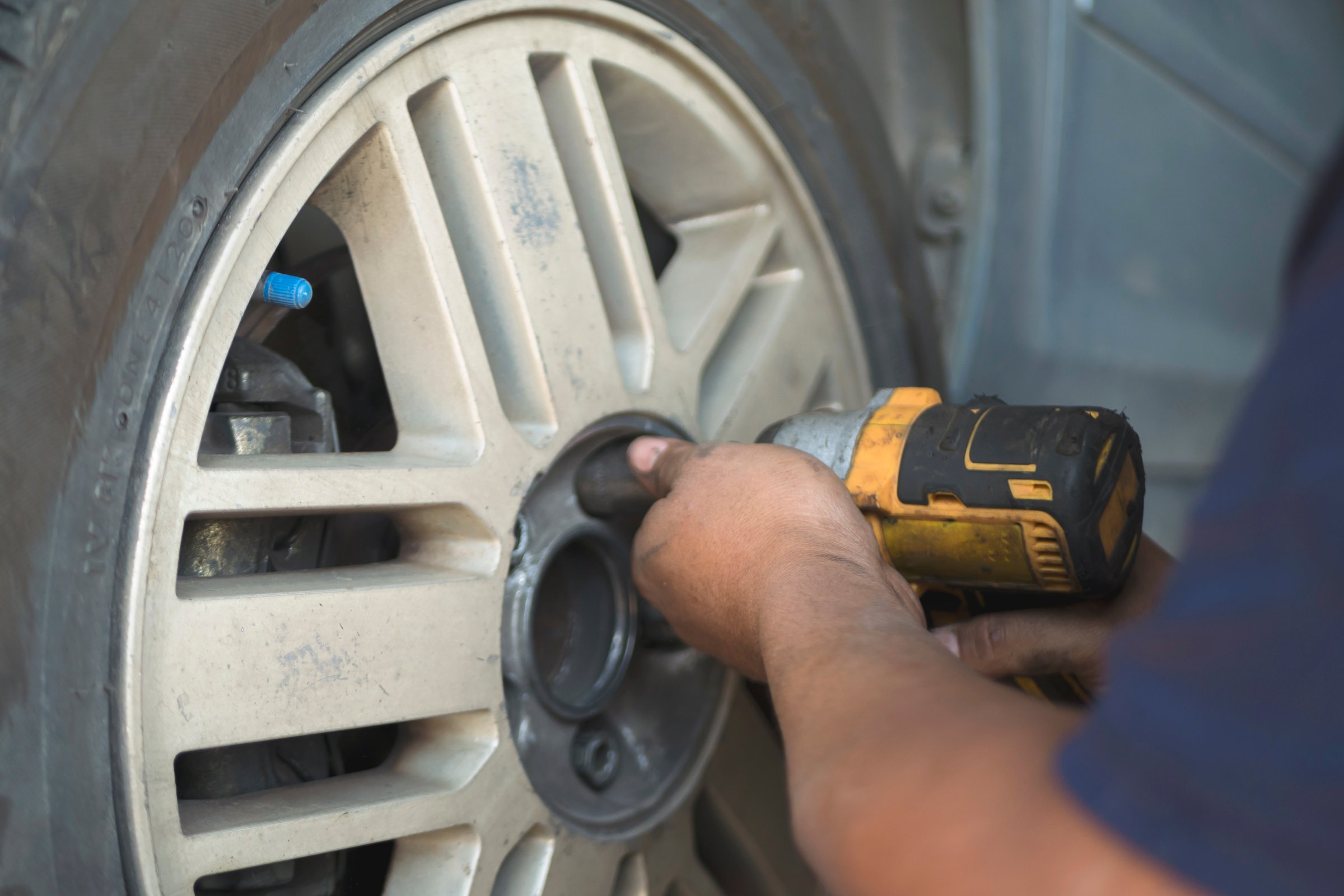 Mechanic man hands checking car tires outdoor on site service