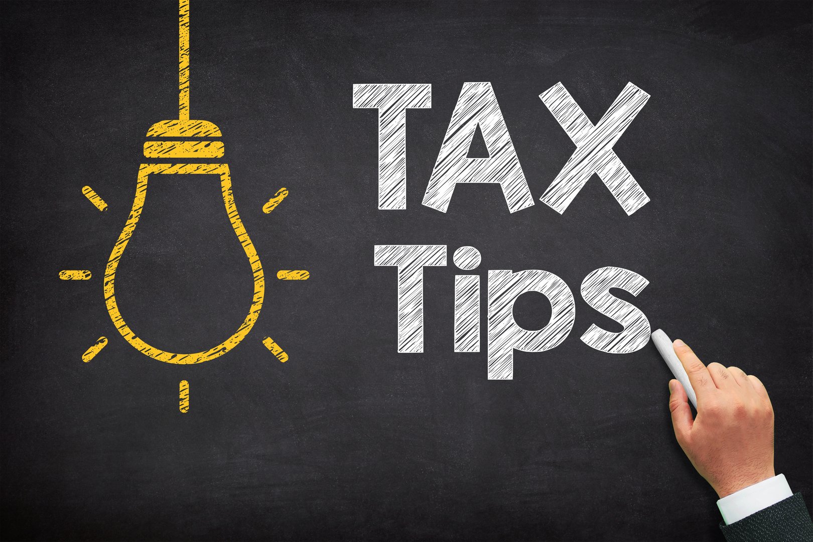 Tax Tips concept with lightbulb icons on black chalkboard