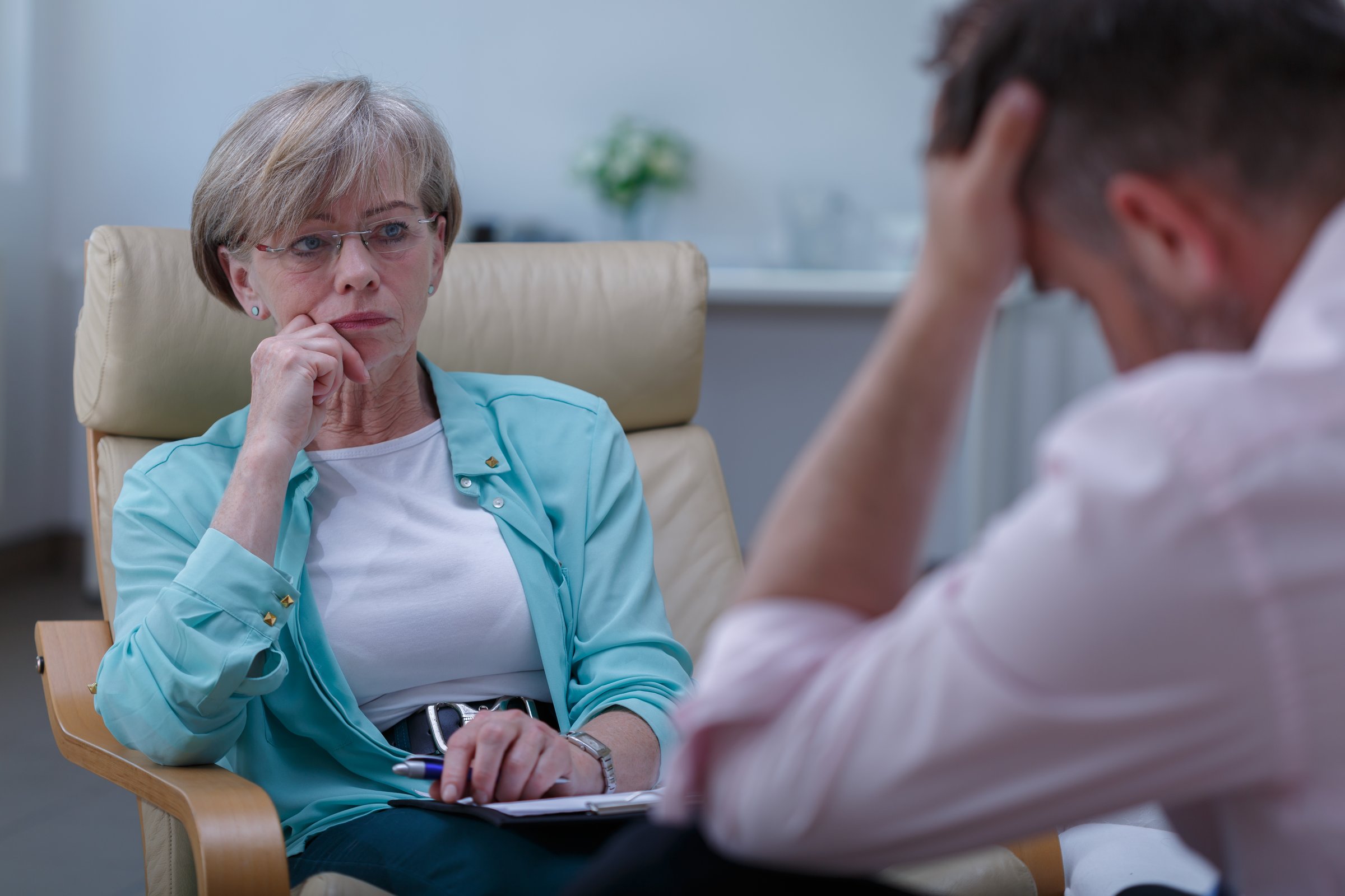 Photo of professional female therapist listening to male patient