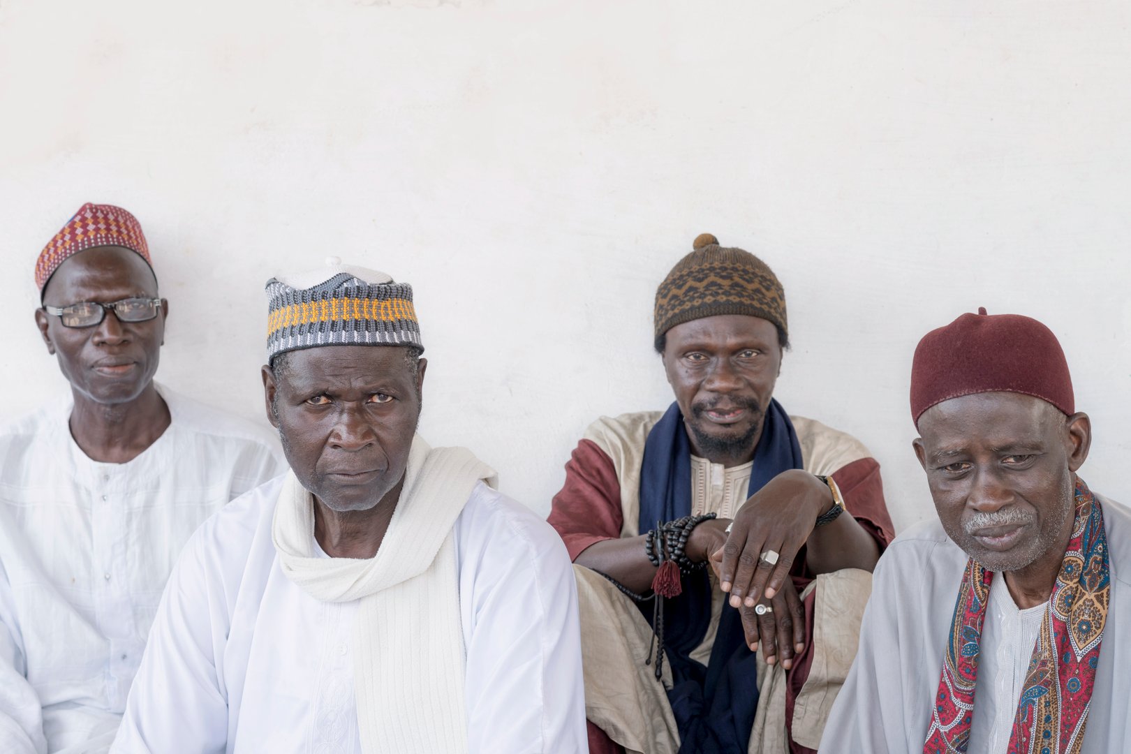 Thiaroye, Dakar, Senegal, Africa – September 3, 2021: Four Muslim men, a Friday in Senegal. Unidentified old Muslim men waiting for the opening of the mosque, celebration clothing