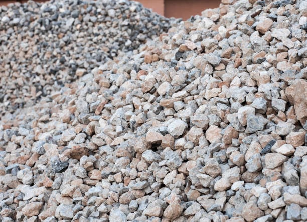 Large pile of mixed gray and brown crushed stones, suitable for construction or landscaping.