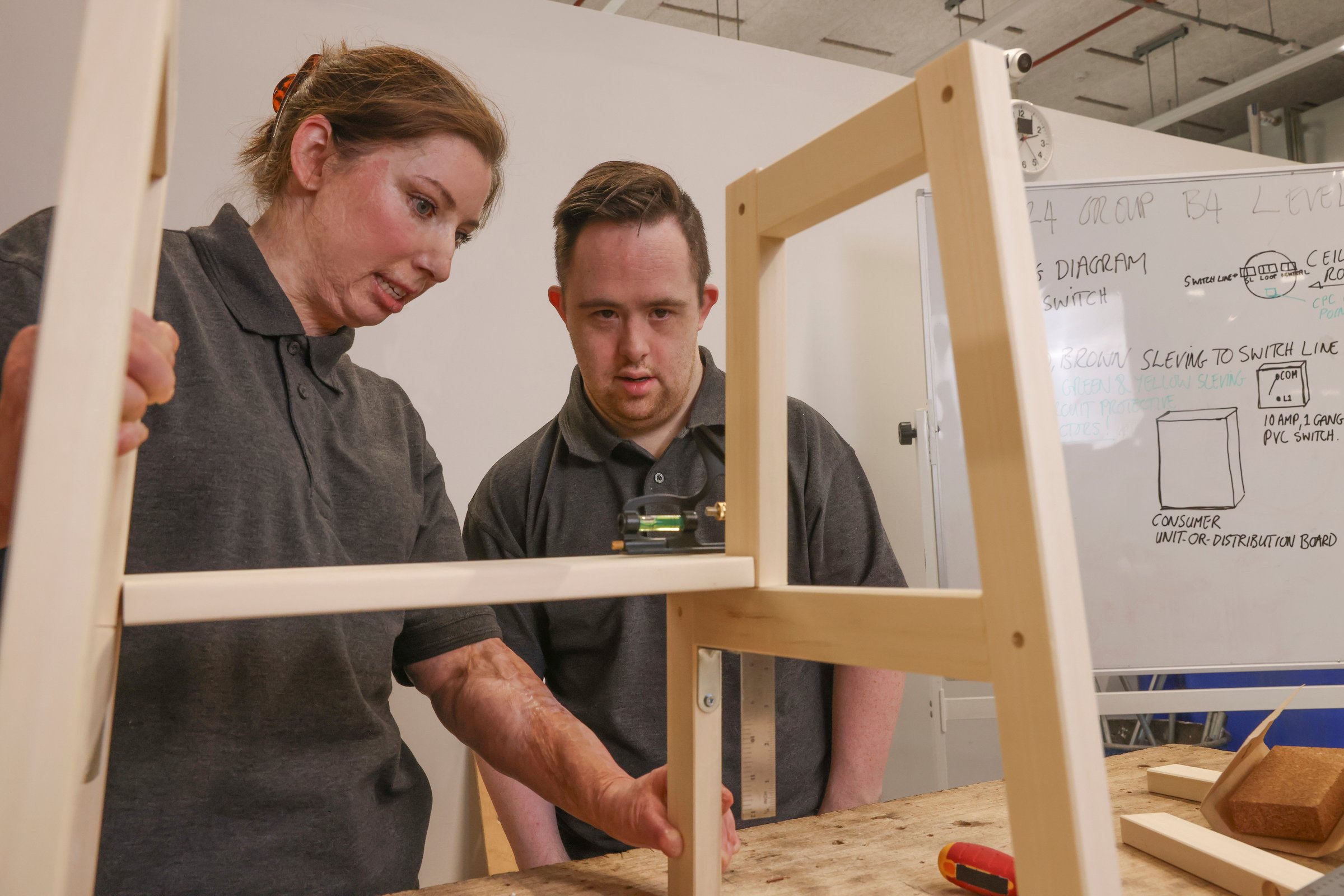 Man and woman with various disabilities working at carpentry workshop