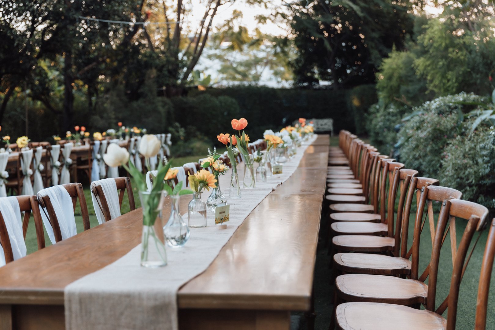 Colorful floral decoration for wedding banquet. Elegant atmosphere on a long narrow table decorated with various flowers at the wedding.