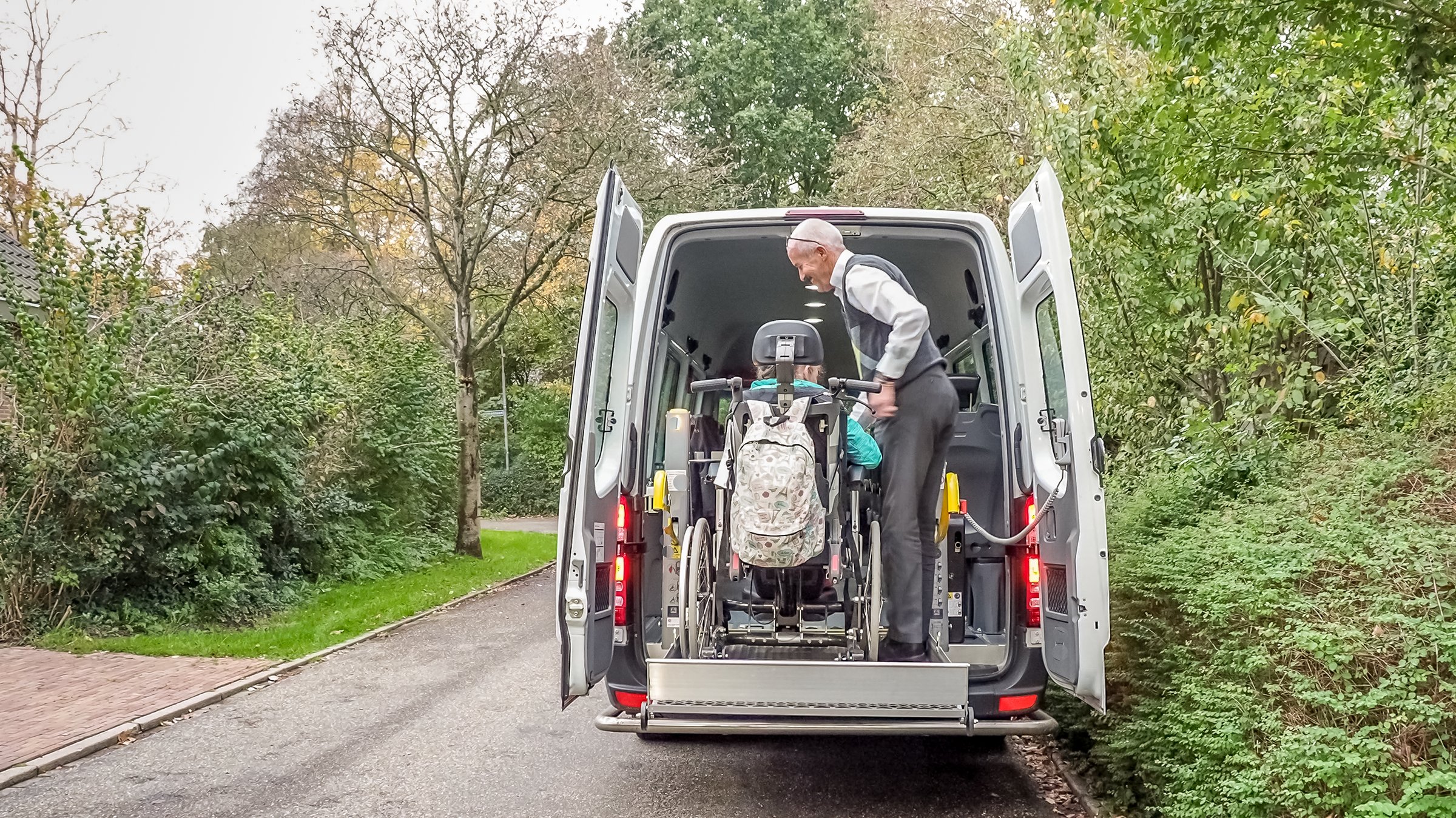 A driver of a wheelchair taxi bringing a disabled girl home from school
