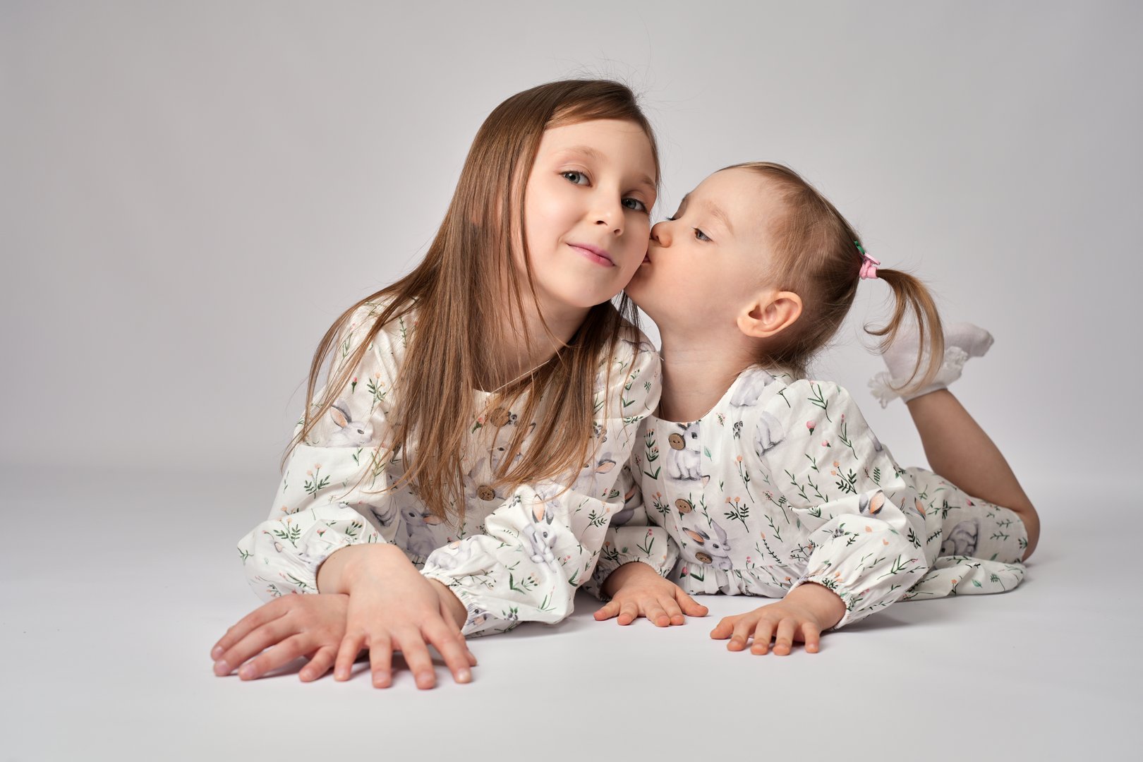 A portrait of two sisters on a white background with copy space. Happy children having fun together. Two cute children baby girls playing and hugging