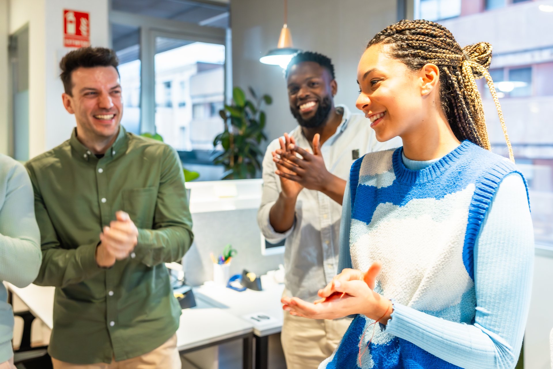 Multi-ethnic business team clapping hands, celebrating success in the office, showing appreciation and recognition for achievement