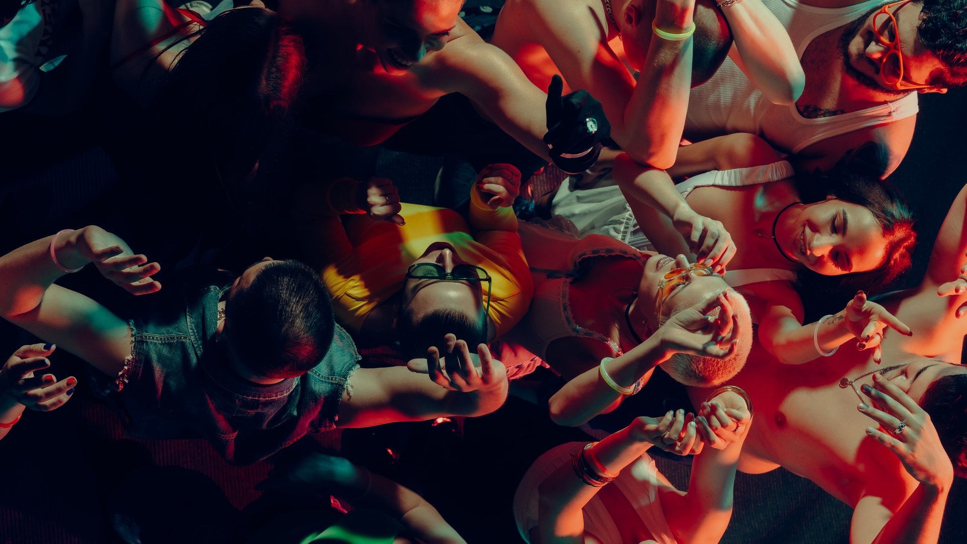 Aerial view of vibrant crowd dancing energetically under colorful lights at a lively party. Concept of nightlife party, youth, summer, festivity, celebration