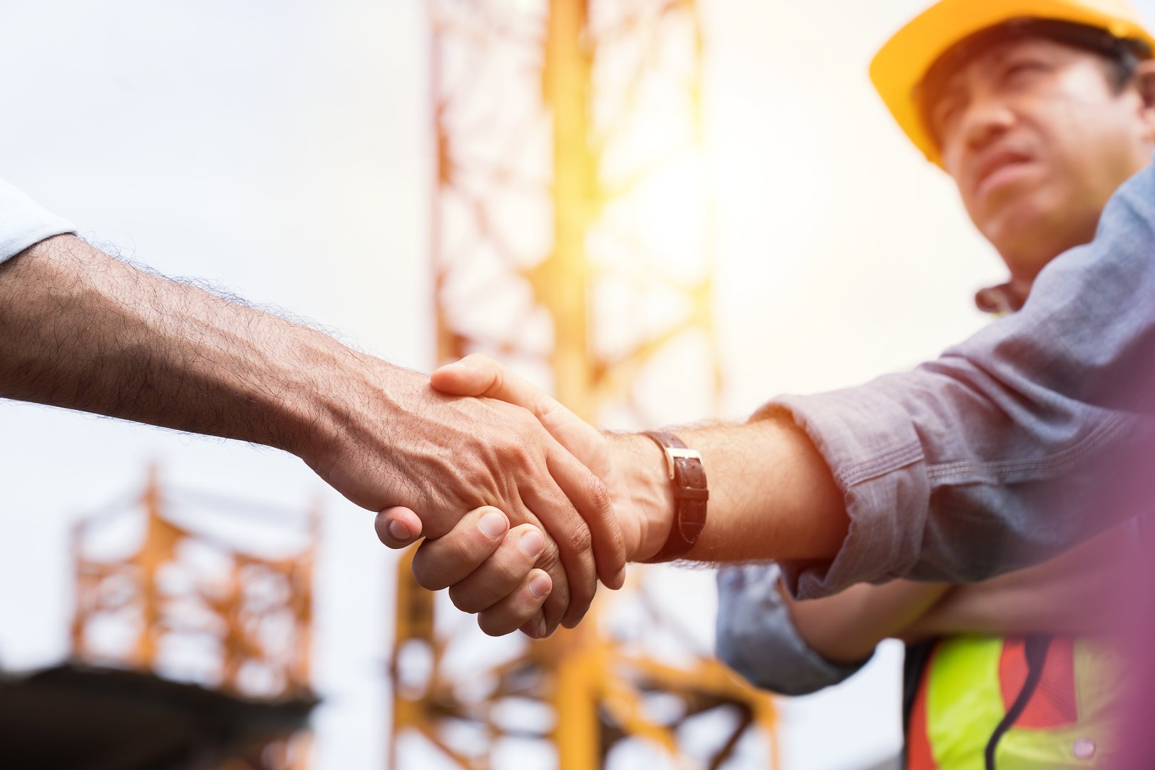 Engineer, Join hands, Team of engineer construction at site. Group of male engineer construction handshake together at construction site. Unity, cooperation and teamwork concept
