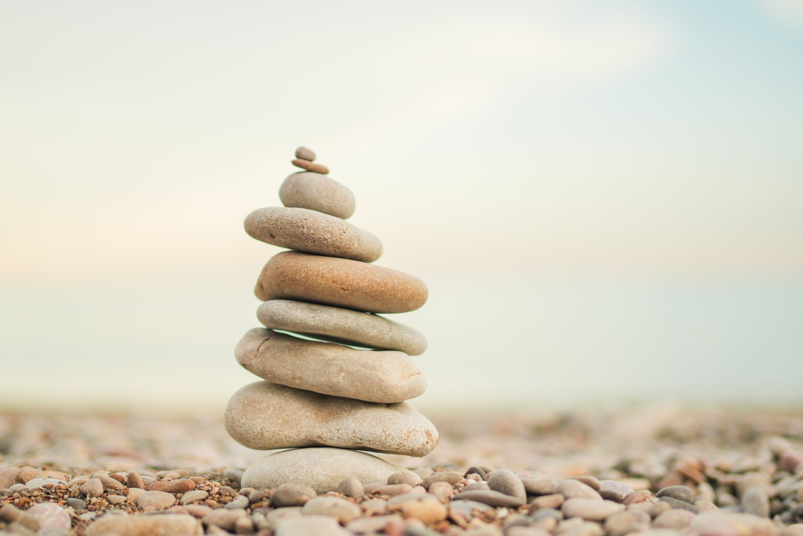 A stack of rocks on a beach. The rocks are of different sizes and are piled on top of each other. Concept of tranquility and peace, as the rocks seem to be in harmony with their surroundings