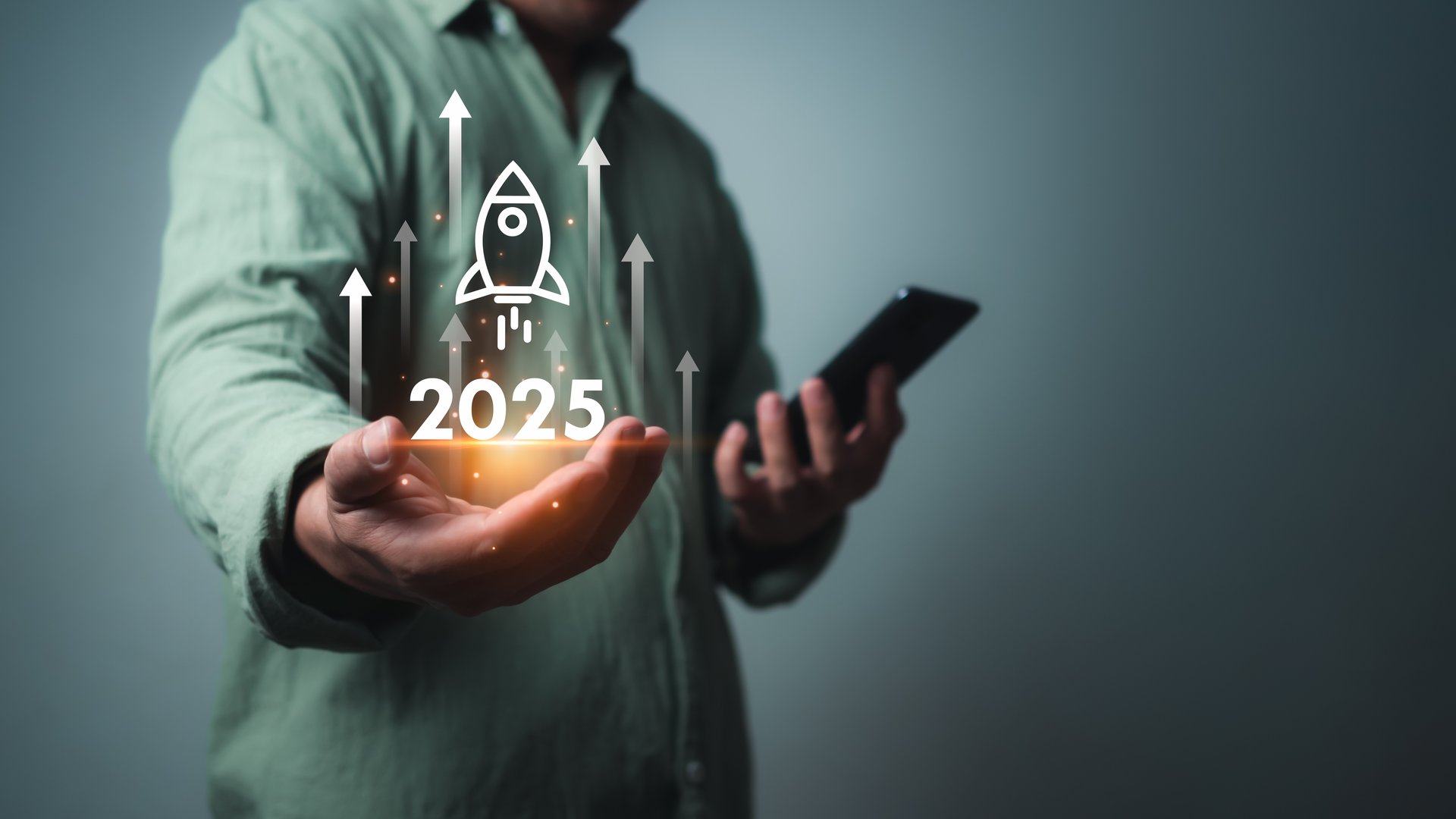 Businessman using smartphone with rocket icon and text 2025 for fast start up business, Startup business 2025 concept, Strategic planning and business success, target, stock market, business growth.
