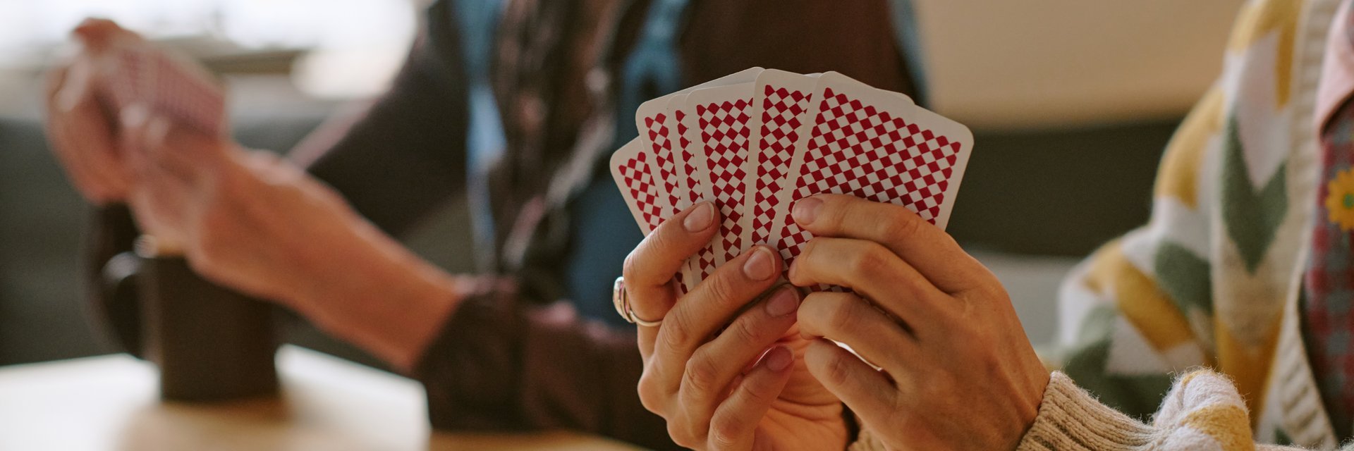 Website banner with unrecognizable female hands holding cards