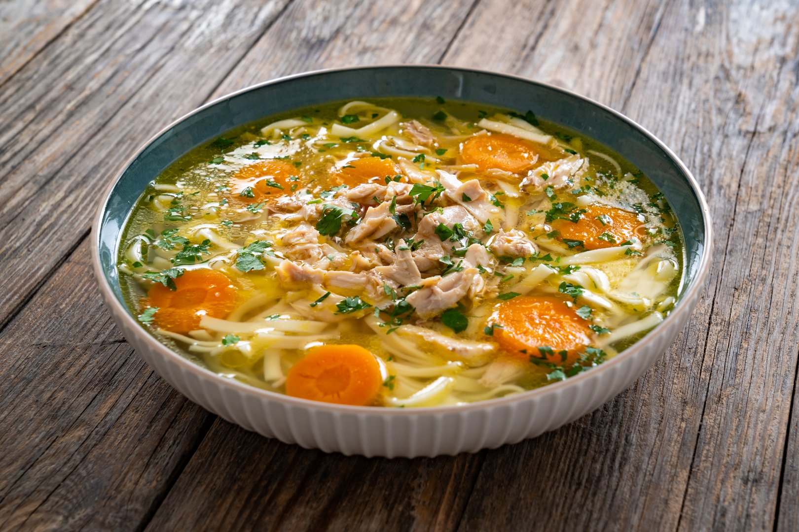 Broth - chicken soup on wooden background