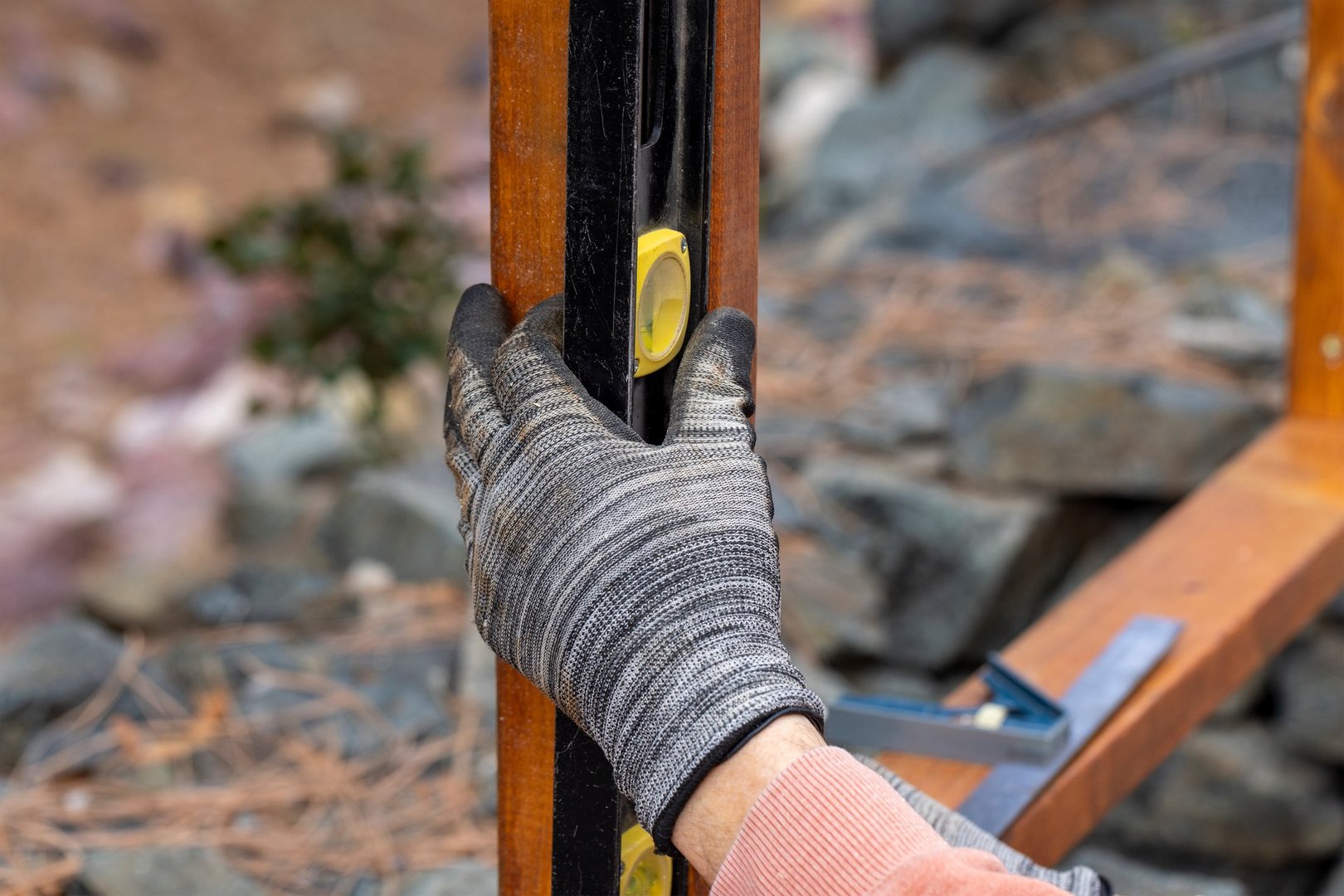 Stained cedar boards being used to build a horizontal fence by a contractor using a battery driven drill