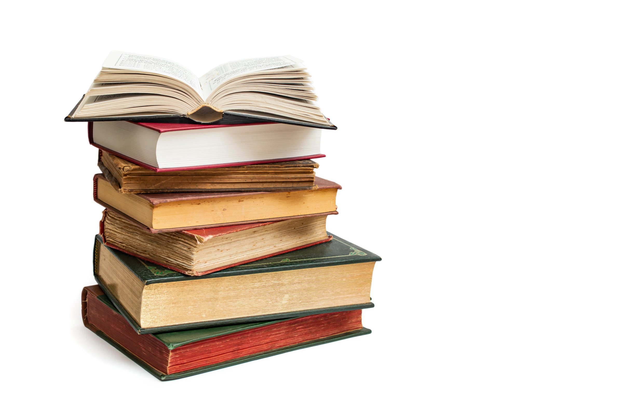 Vintage hard cover books stacked with an opened book on top, isolated on white background,