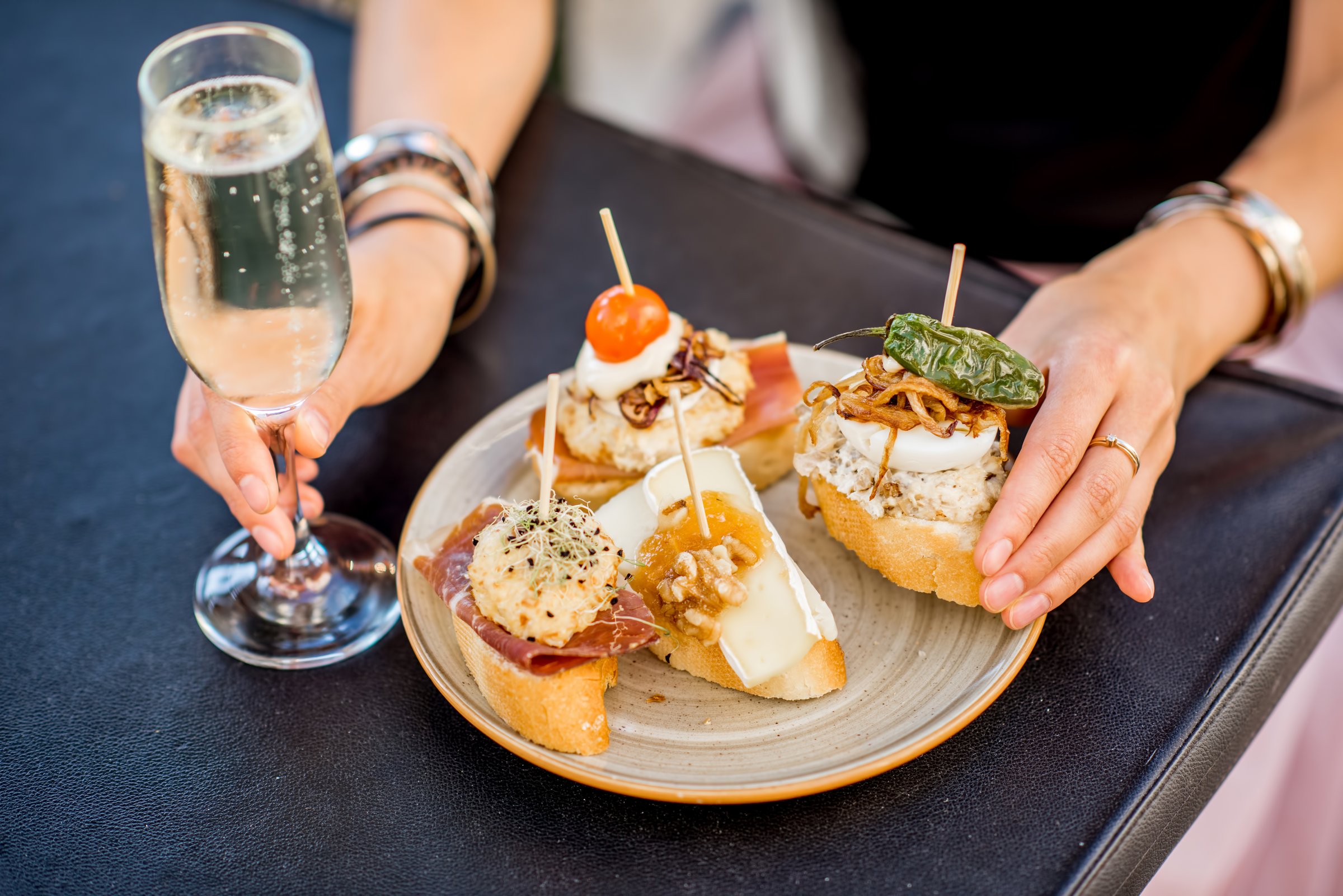 Beautiful and colorful set of pinchos, traditional spanish snack related to tapas, with glass of wine outdoors on the table