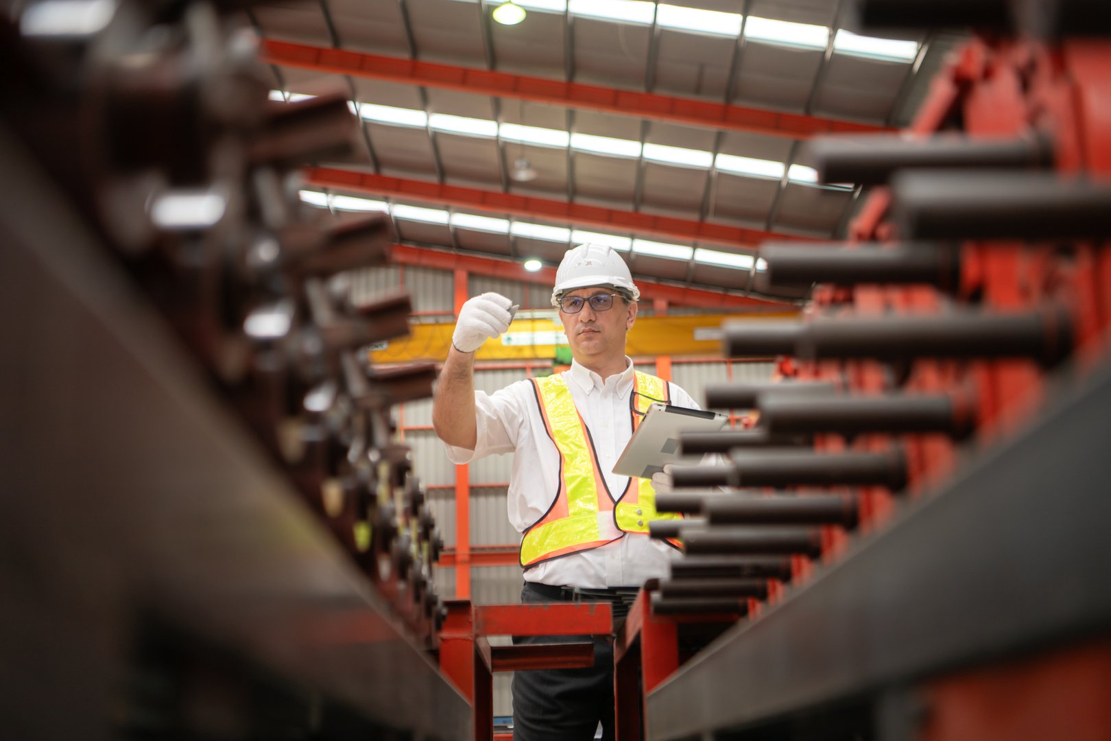 Senior experienced technician checking large machine on a production line at an industrial factory