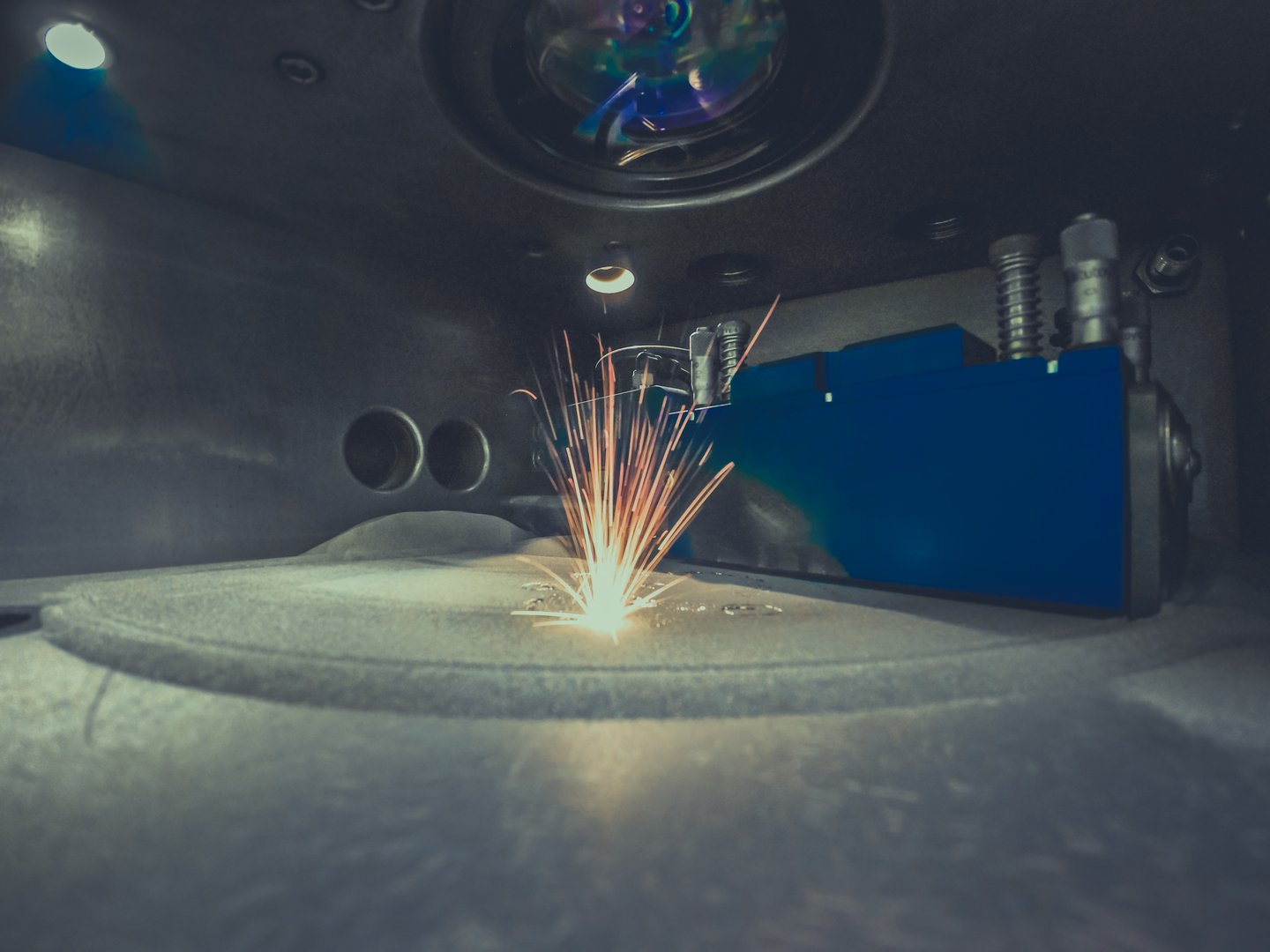 3D printer printing metal. Laser sintering machine for metal. Metal is sintered under the action of laser into shape. DMLS, SLM, SLS. Modern additive technologies 4.0 industrial revolution. Sparks