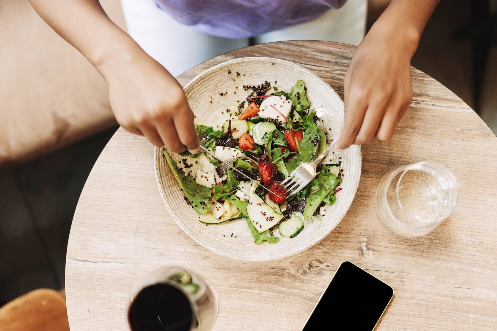 Top view, woman enjoys a delicious and healthy salad for lunch, savoring the fresh ingredients and taking a break from a busy day