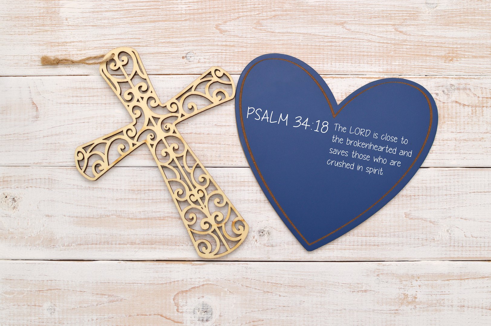 Cross and Heart with biblical quote (Psalm Chapter 34 Verse 18 The LORD is close to the brokenhearted and saves those who are crushed in spirit) on whitewashed wood background