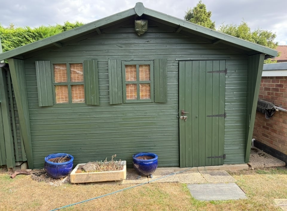Large green shed after professional painting and restoration