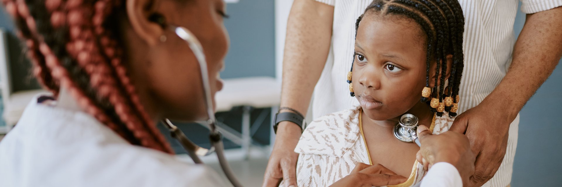 Portrait of young girl receiving pediatric health check by a healthcare professional, looking concerned and curious during medical examination in hospital setting