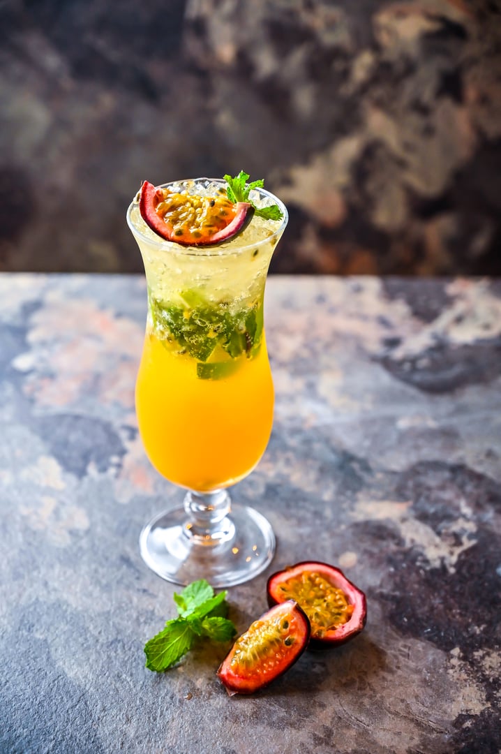 Passion Fruit Mojito Soda with mint served in cocktail glass isolated on dark background side view of healthy drink