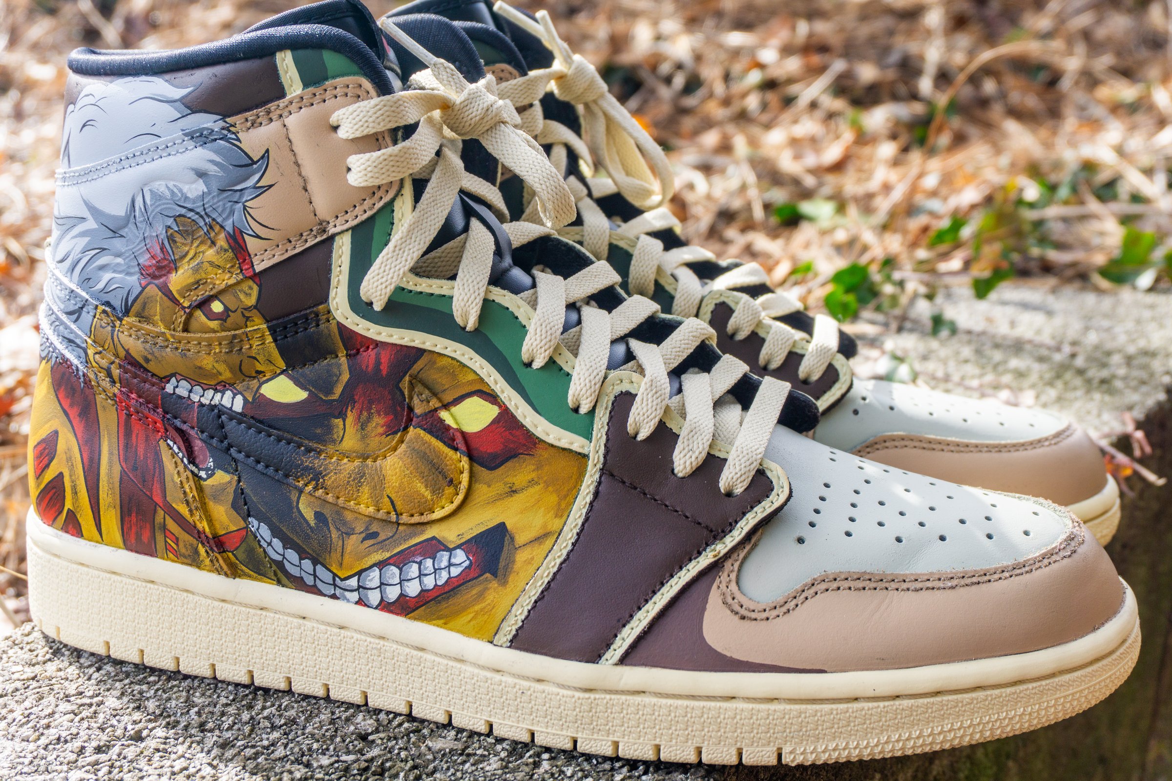 Custom sneakers with intricate, colorful illustrations and detailed character designs on the sides, set outdoors.