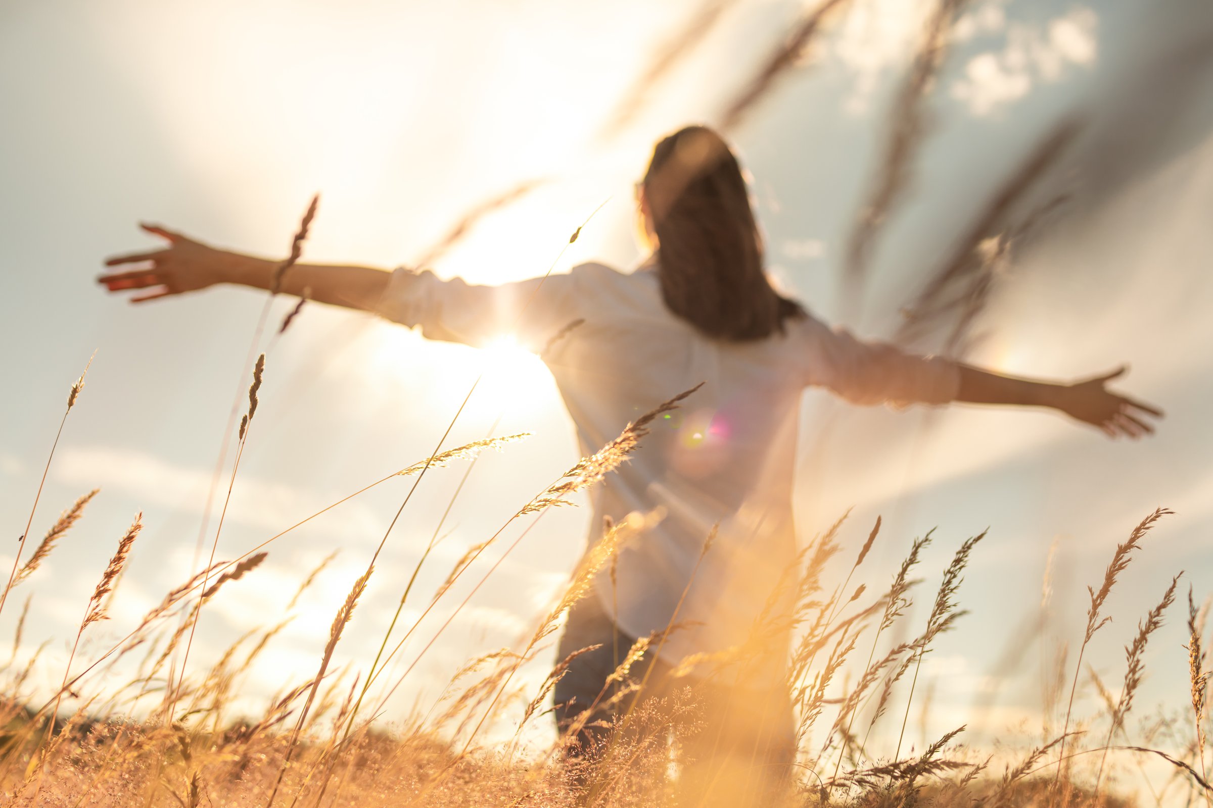 Woman feeling joyful and enjoying the sun in the field.