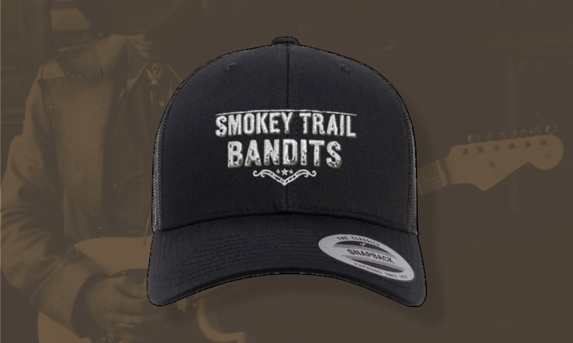 Black baseball cap with Smokey Trail Bandits embroidered on the front, displayed against a sepia-toned background.