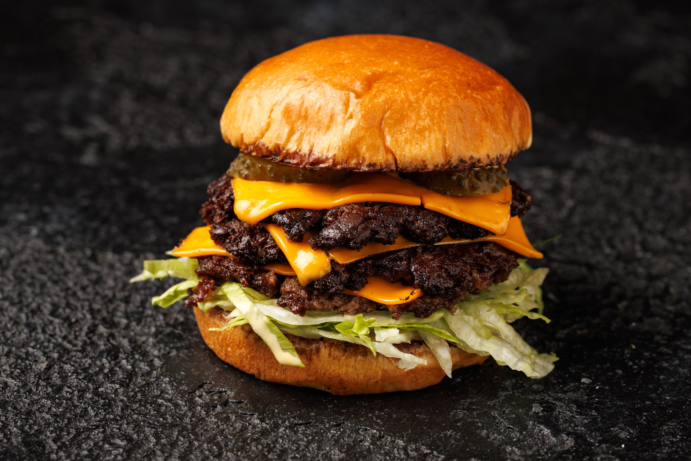 Smash burger with lettuce, cheddar cheese and sauce.