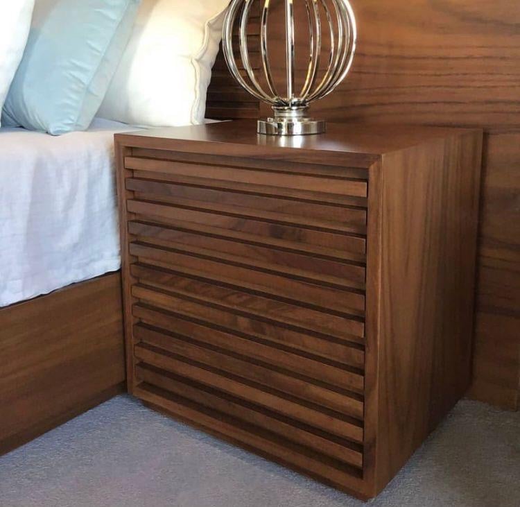 Buró de parota con frente ranurado tipo louver que disimula los cajones ocultos