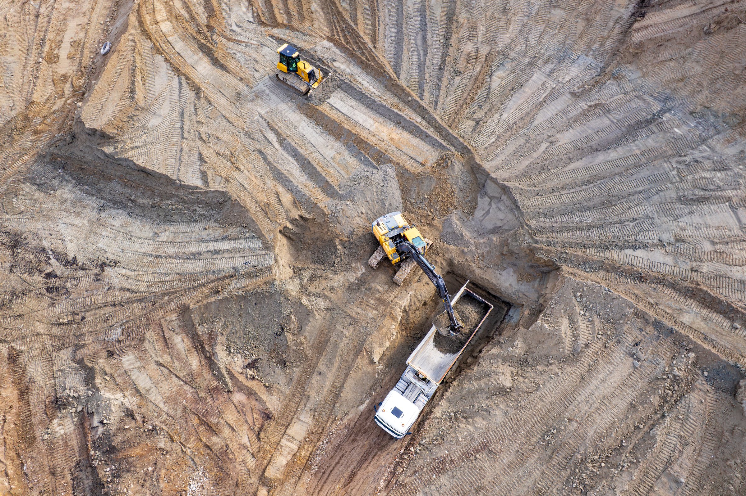 excavator seen removing earth and loading into a nearby dumper truck