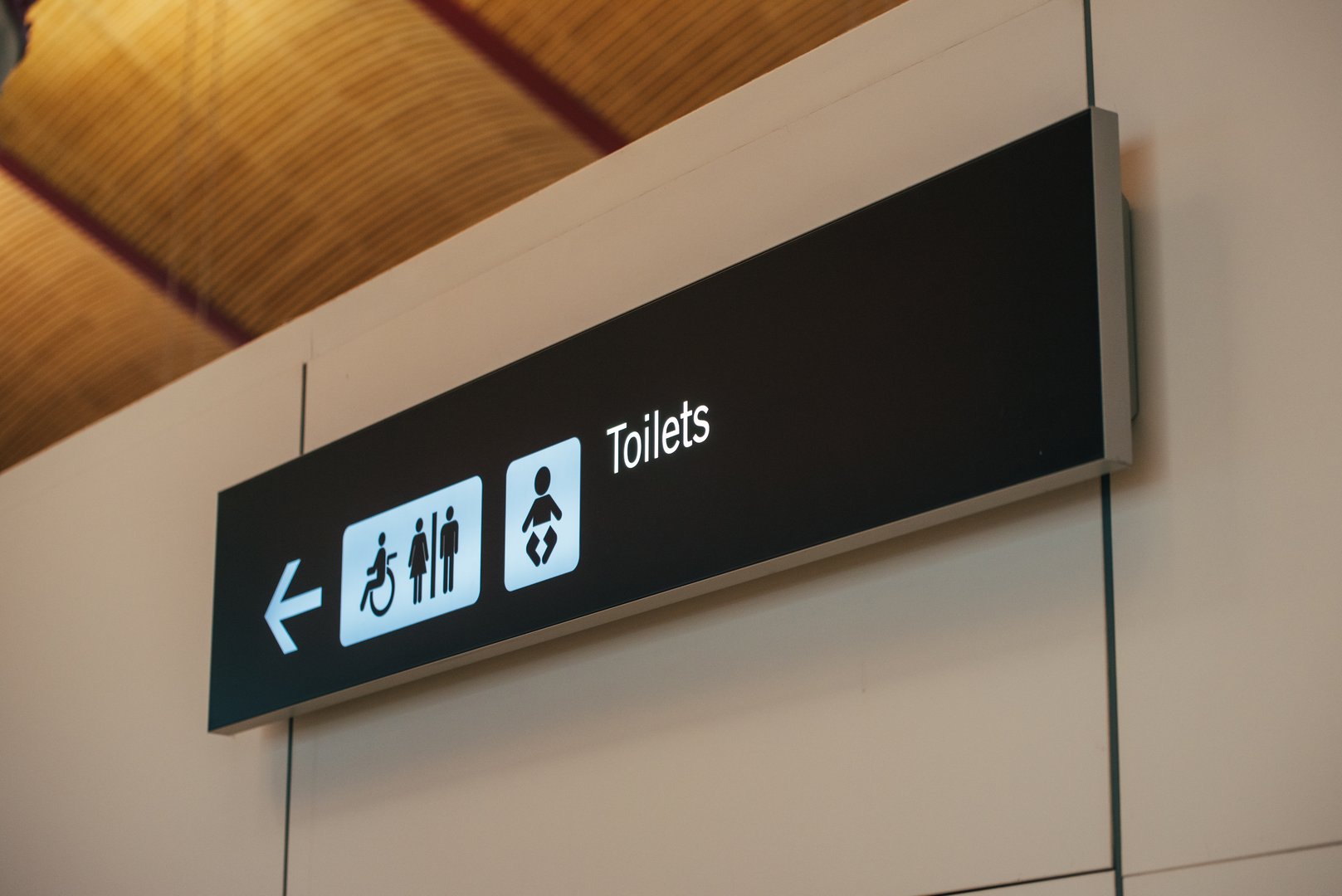 Toilet sign direction at airport showing wayfinding and directional signage