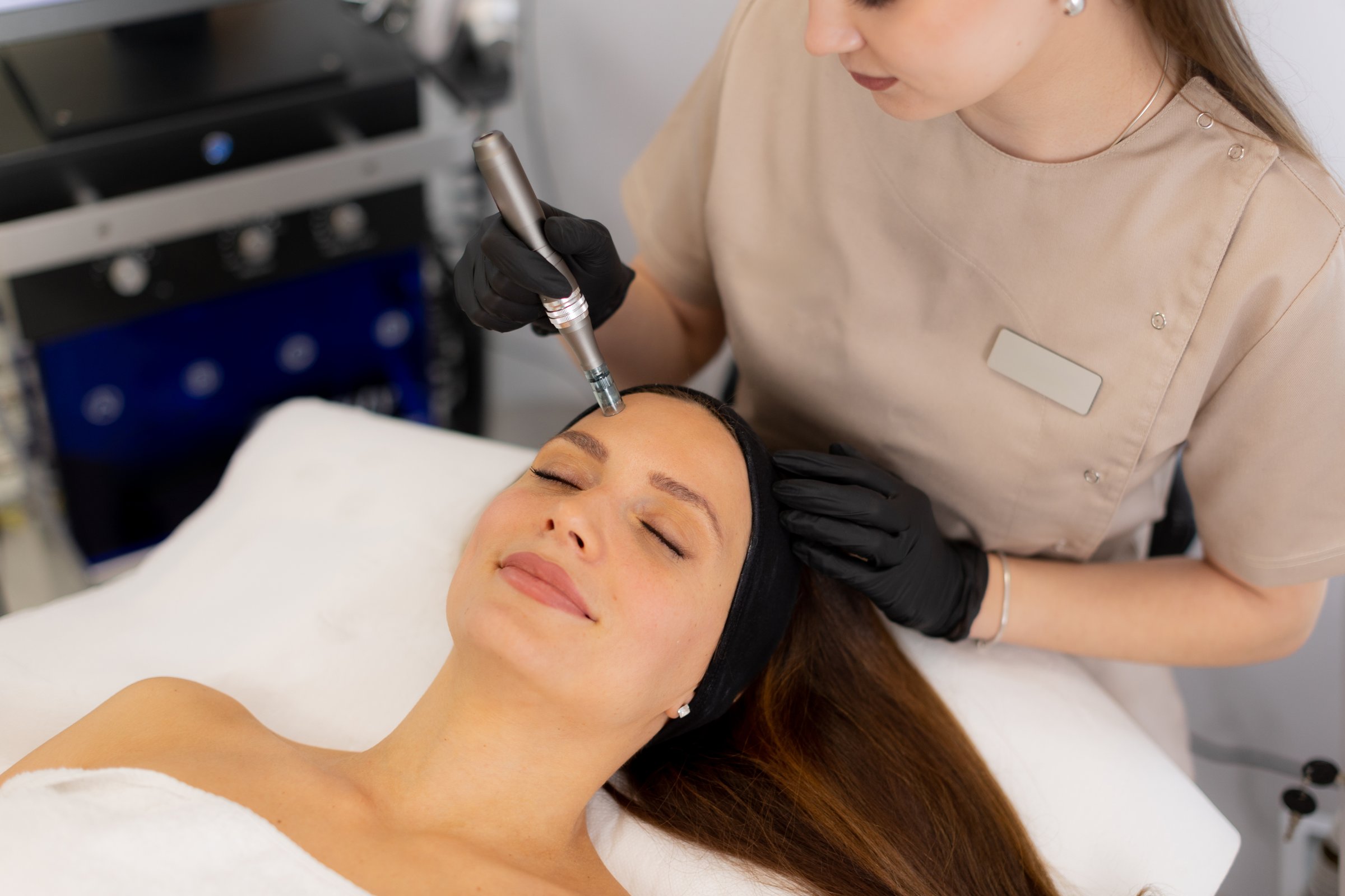 A skilled professional uses a microneedling mesotherapy device on a client in a serene clinic, focusing on skin rejuvenation and enhancing beauty. The environment is calm and sterile.