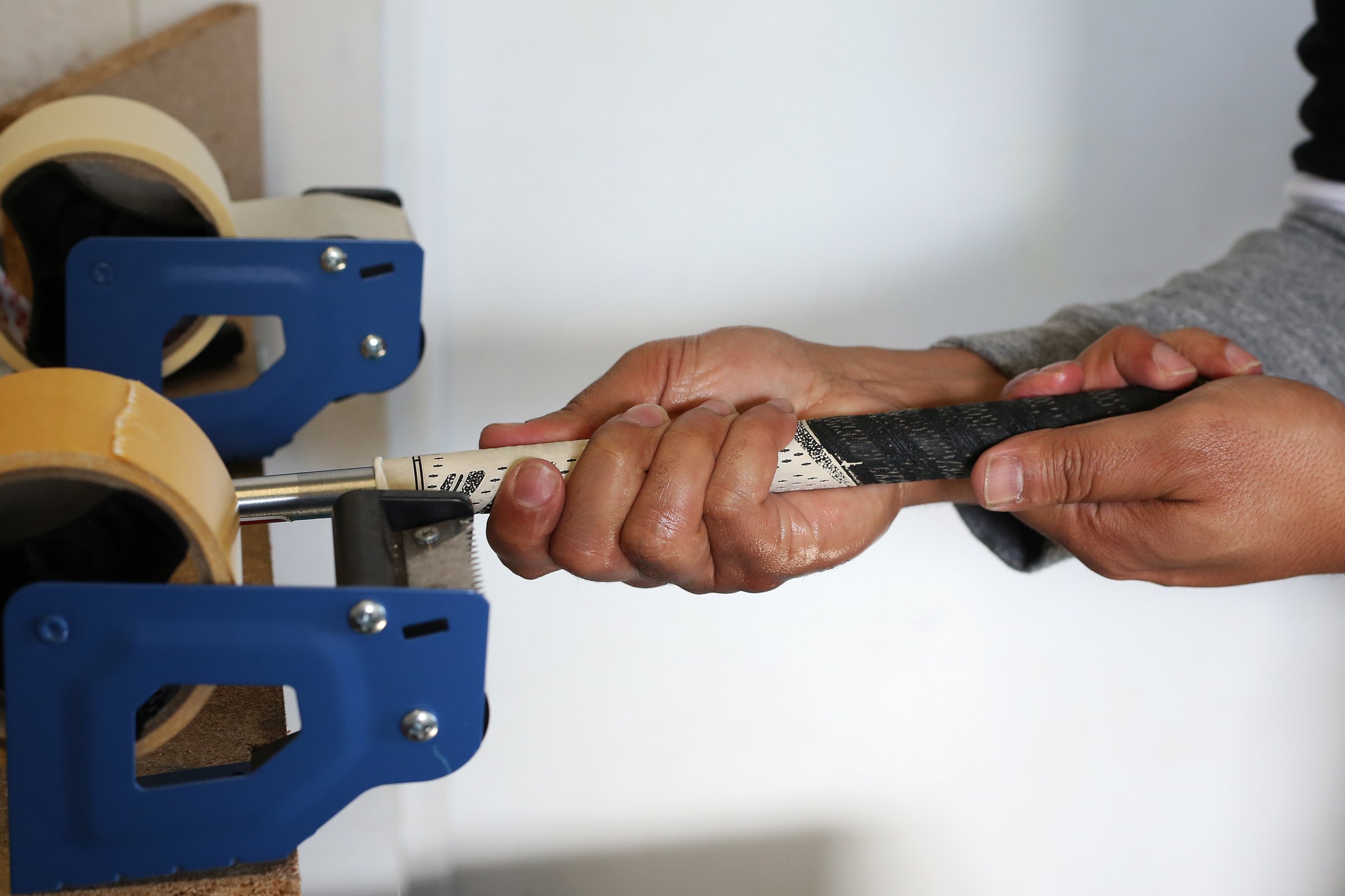 A Golf Club Builder slides on the new grip to the golf club.