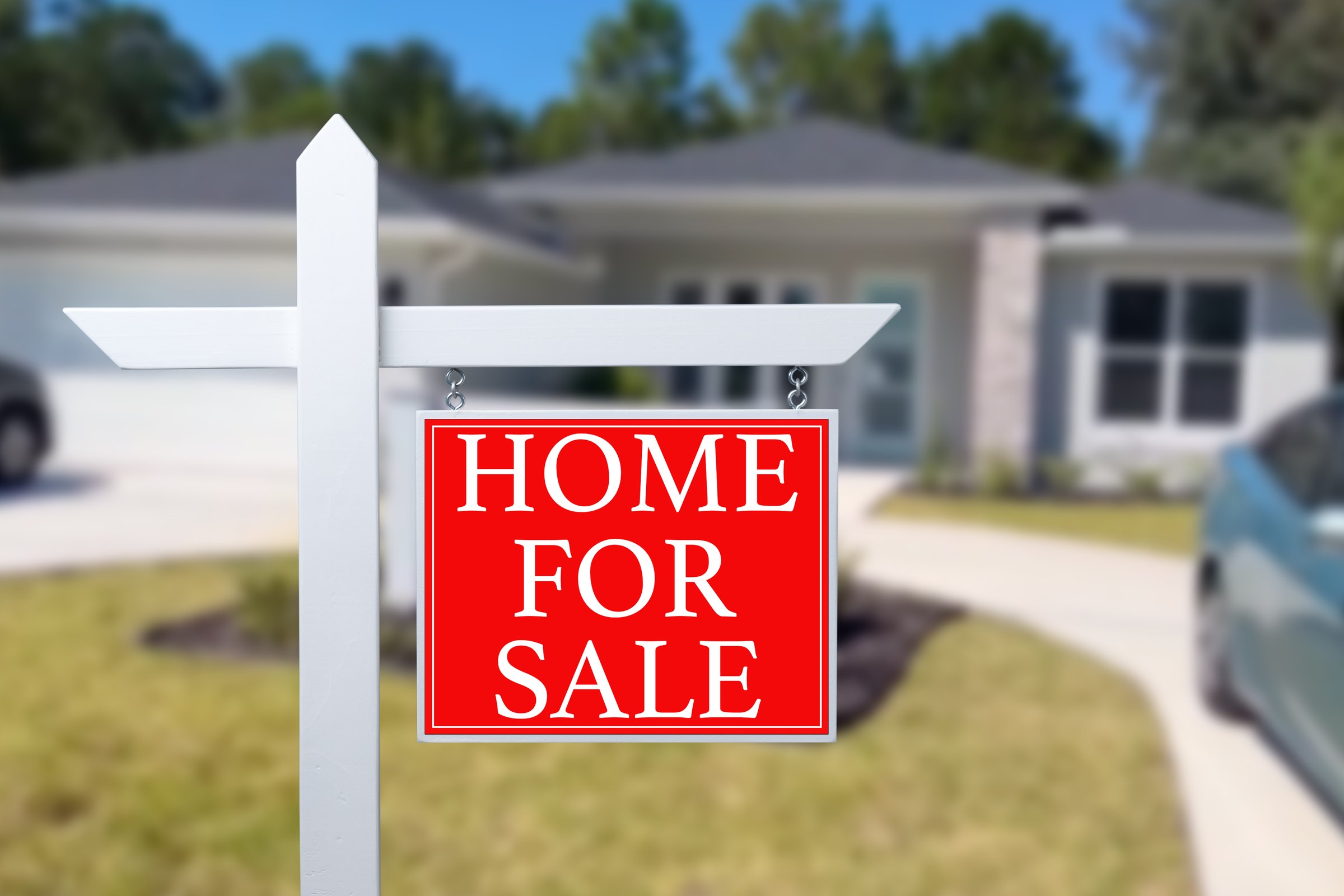 Home For Sale Real Estate Sign and Beautiful New House