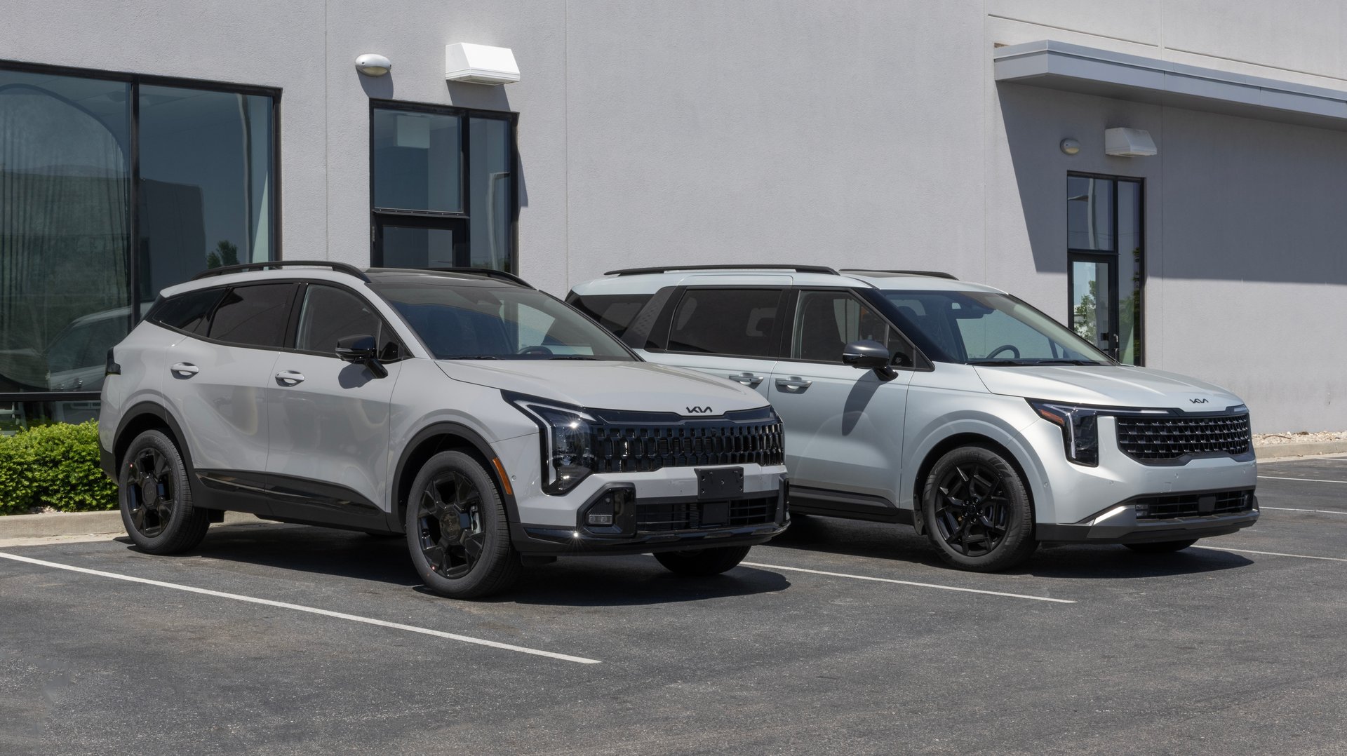Avon - May 18, 2025: Kia Sportage and Carnival SUV at a dealership. Kia offers the Sportage and Carnival with Direct Injection engines. MY:2025