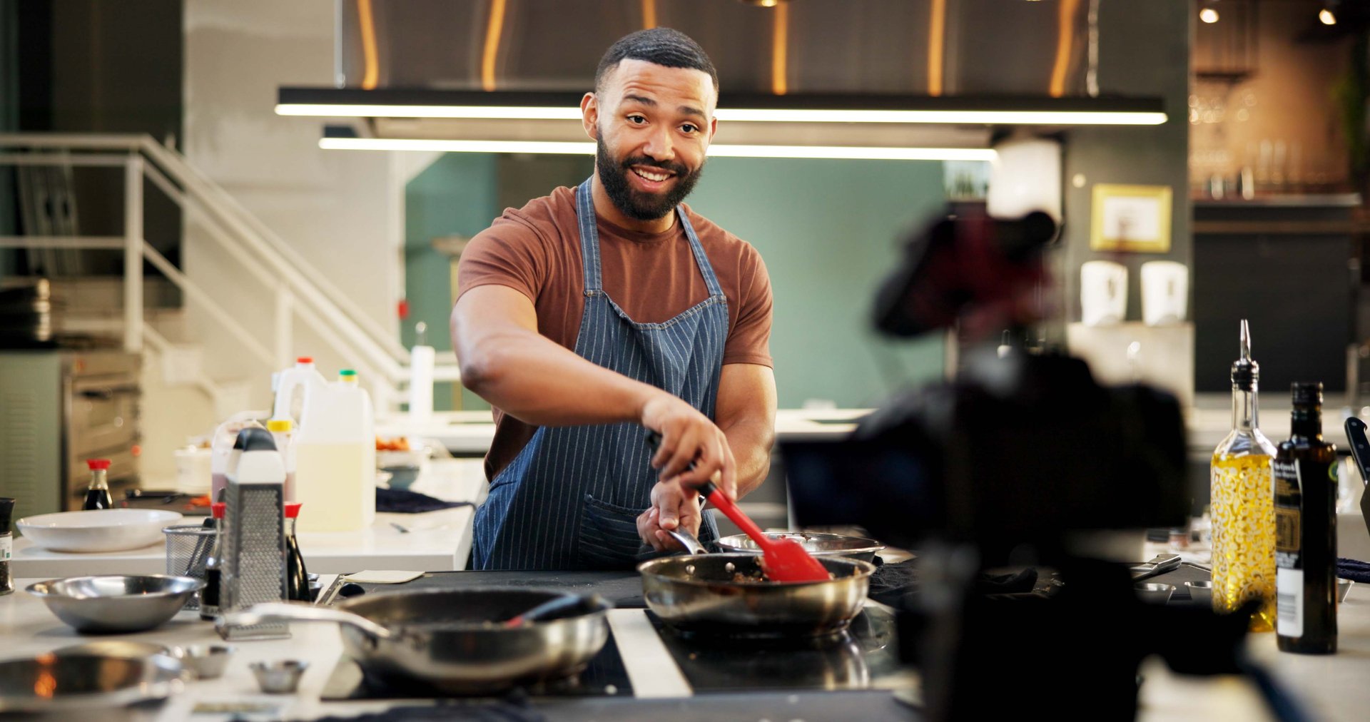 Chef, man and cooking vlog in kitchen for live streaming, recipe tutorial and filming food video in home. Content creation, happy influencer and recording online class for meal preparation or cuisine