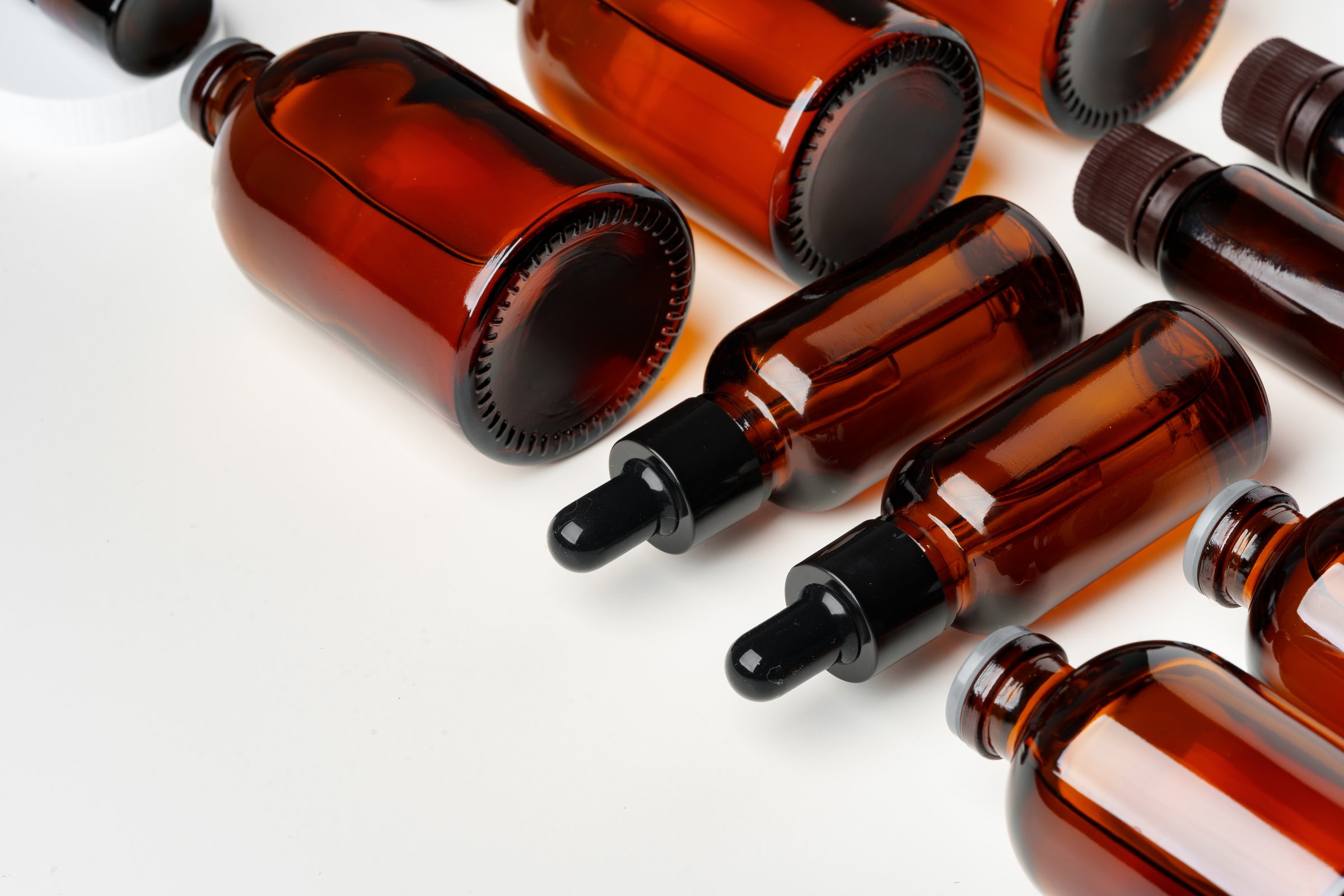 Mock up of amber glass bottles on white background flat lay top view
