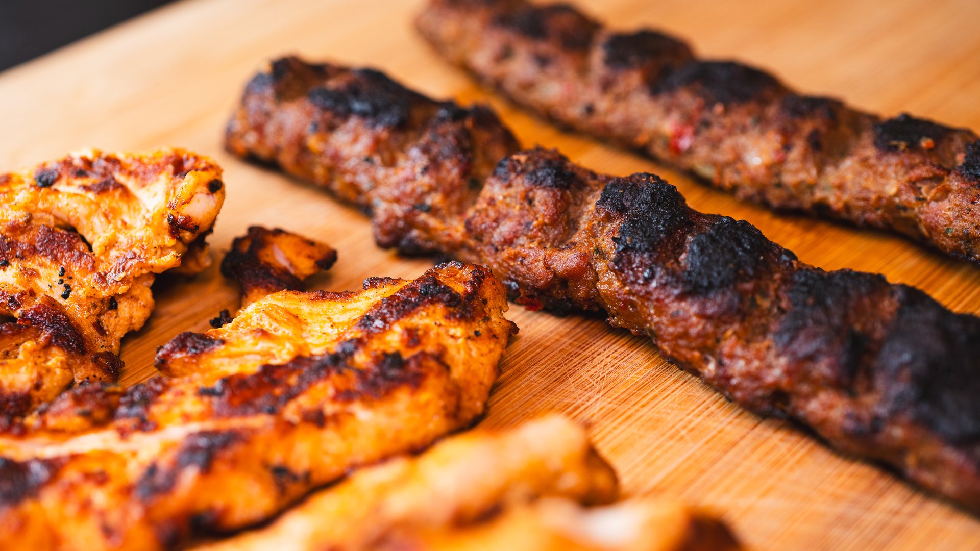 Delicious and healthy mixed grill platter featuring juicy chicken shish, tender lamb shish, and sliced chicken doner kebab. Served on a rustic wooden board. Perfect for food blogs, menus, and promoting Mediterranean or Middle Eastern cuisine.