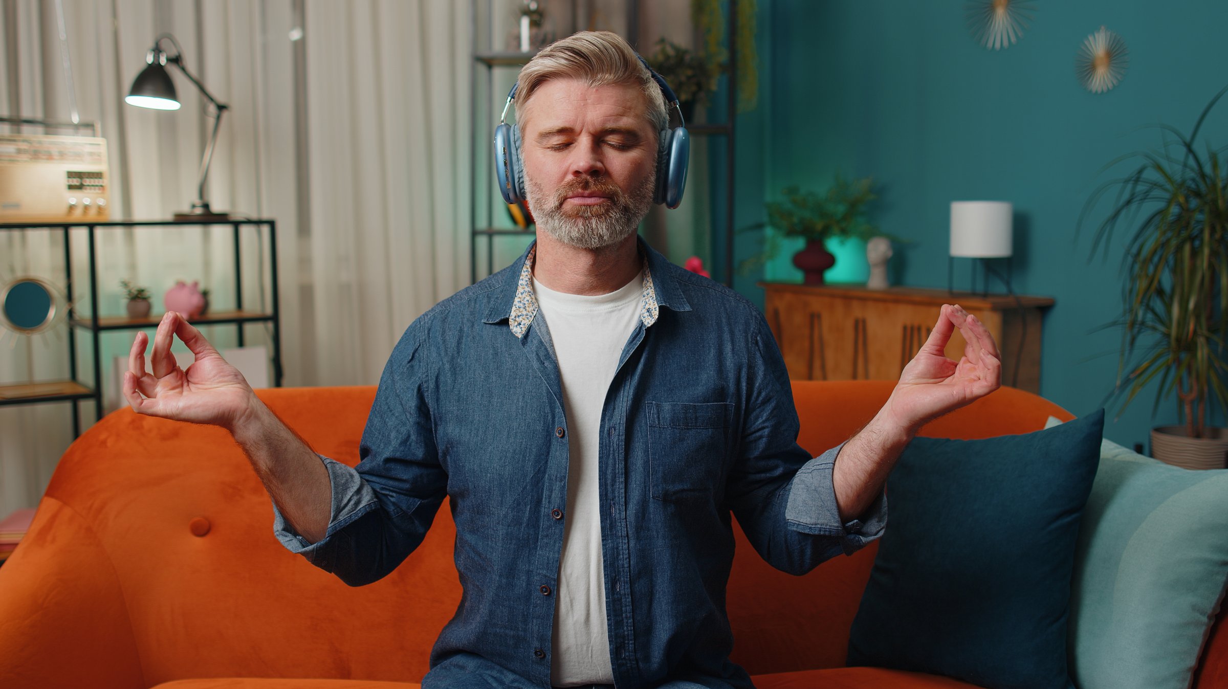 Muškarac praktikuje duboko disanje i meditaciju kod kuće - vježbe opuštanja za smanjenje stresa