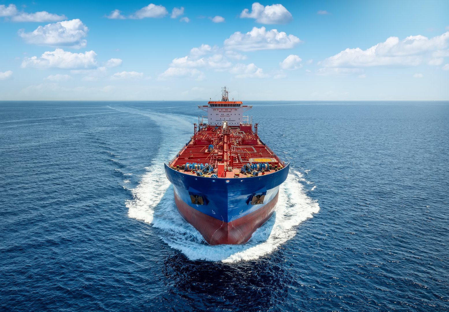 Aerial front view of a heavy crude oil tanker traveling with speed over the ocean