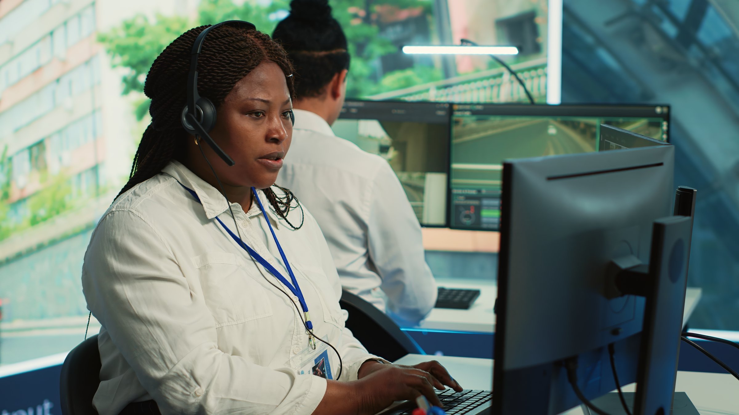 African american operator gathers gps coordinates and data for the government database, monitoring cars in traffic via surveillance CCTV security systems. Real time radar recordings. Camera A.