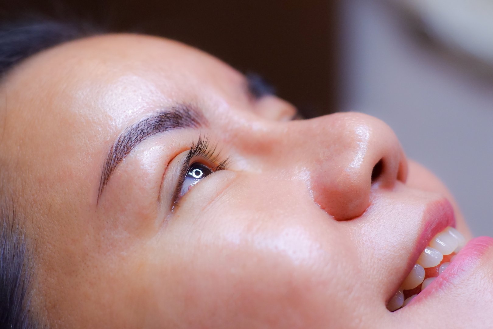 Beautiful female customer after having her eyebrows tattooed by a professional technician. At the eyebrow tattoo shop Beautiful eyebrow lines Asian woman with dark brown hair