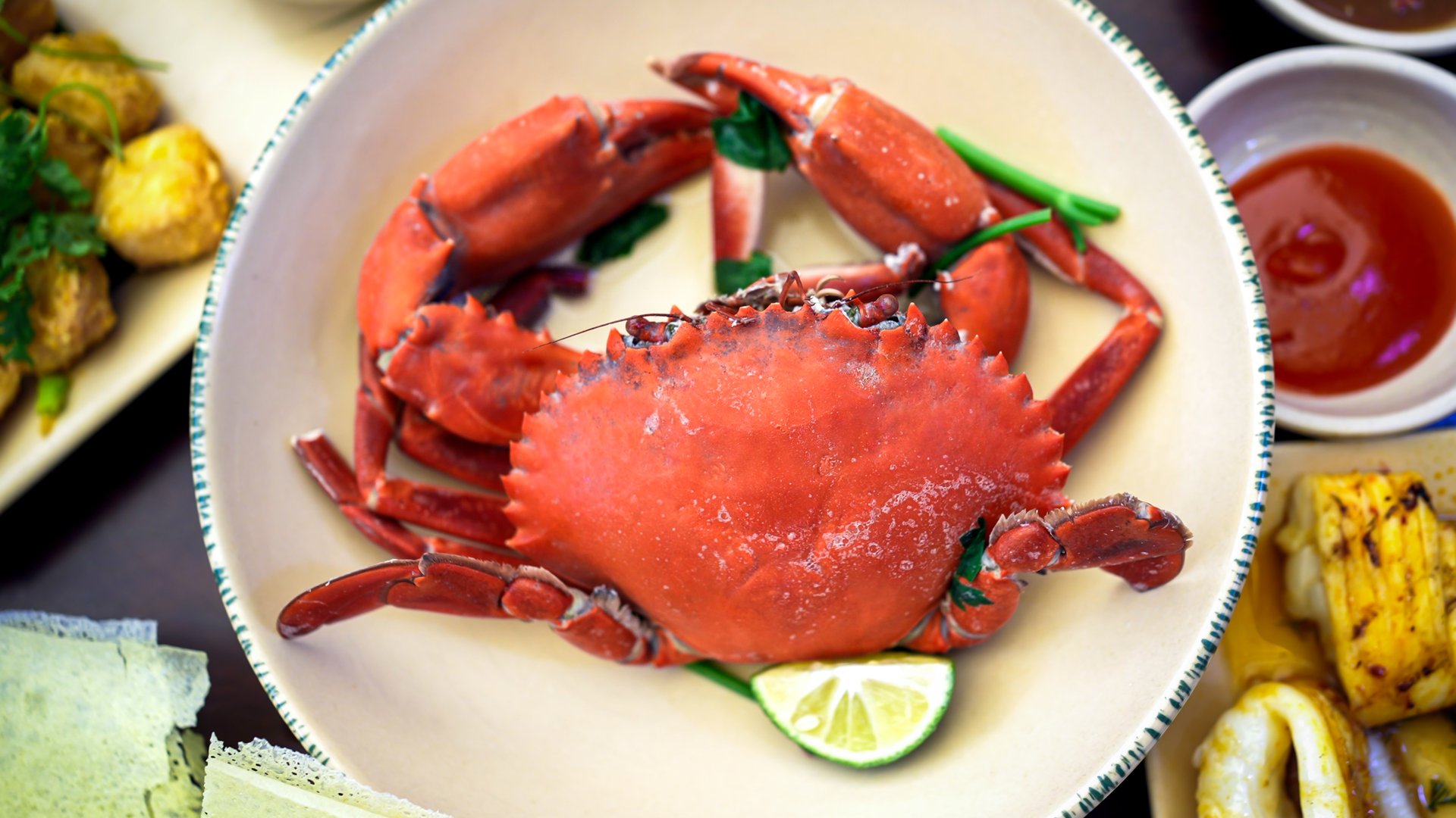 A Vietnamese dish of cooked crab garnished with lime slices and fresh herbs, served in a bowl. This popular dish is a staple in Vietnamese cuisine, known for its rich and delicious flavors.