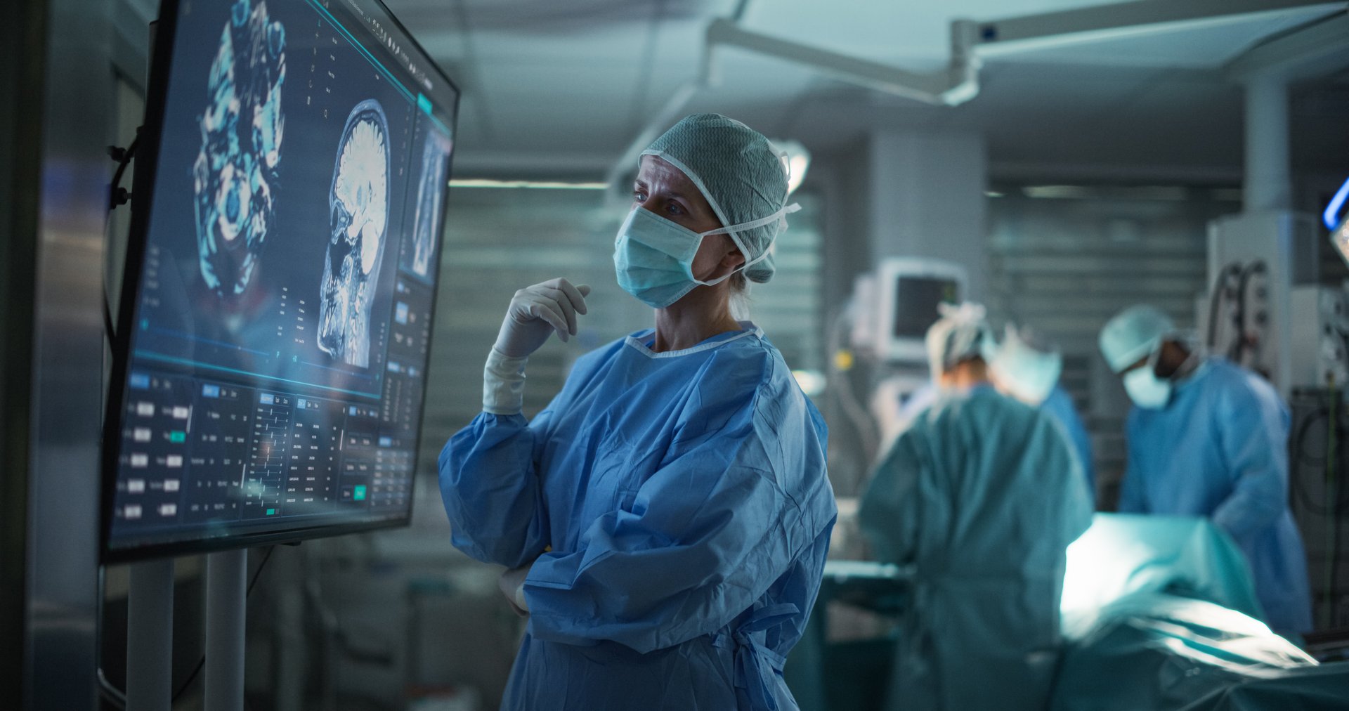 Professional Focused Caucasian Female Surgeon Reviewing Patient's Brain Scans on a Large Monitor, Preparing to Lead Her Team in a Complex Surgery, Analyzing Data Before the Procedure Begins
