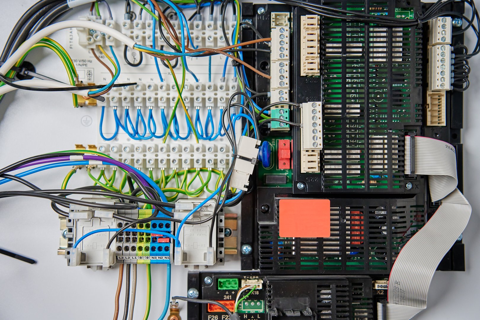 Close-up view of wiring system and circuit board inside electrical control panel. Electrical components used for automation and regulation of various systems