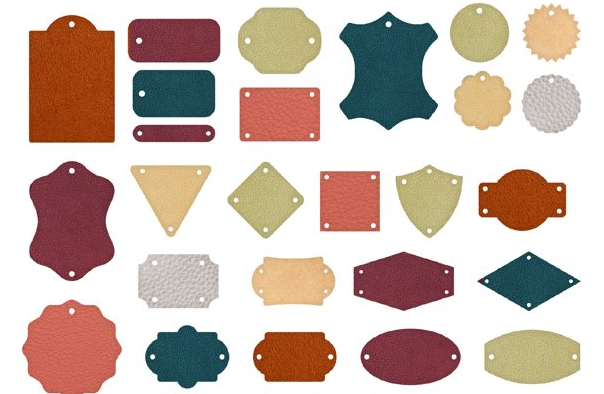 Various leather tags in different shapes and colors with holes for attachment, displayed on a white background.